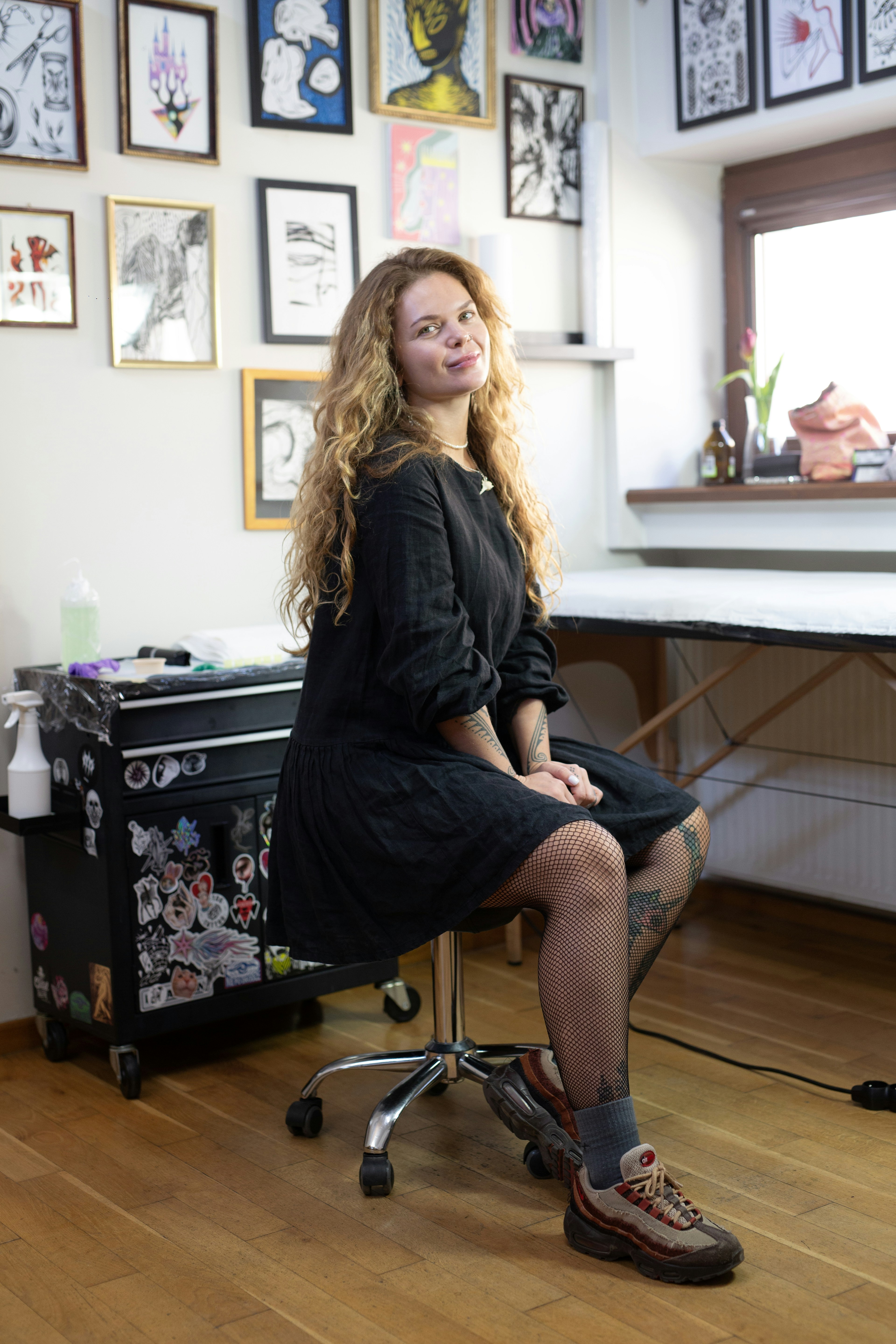 Woman with curly hair in a tattoo studio