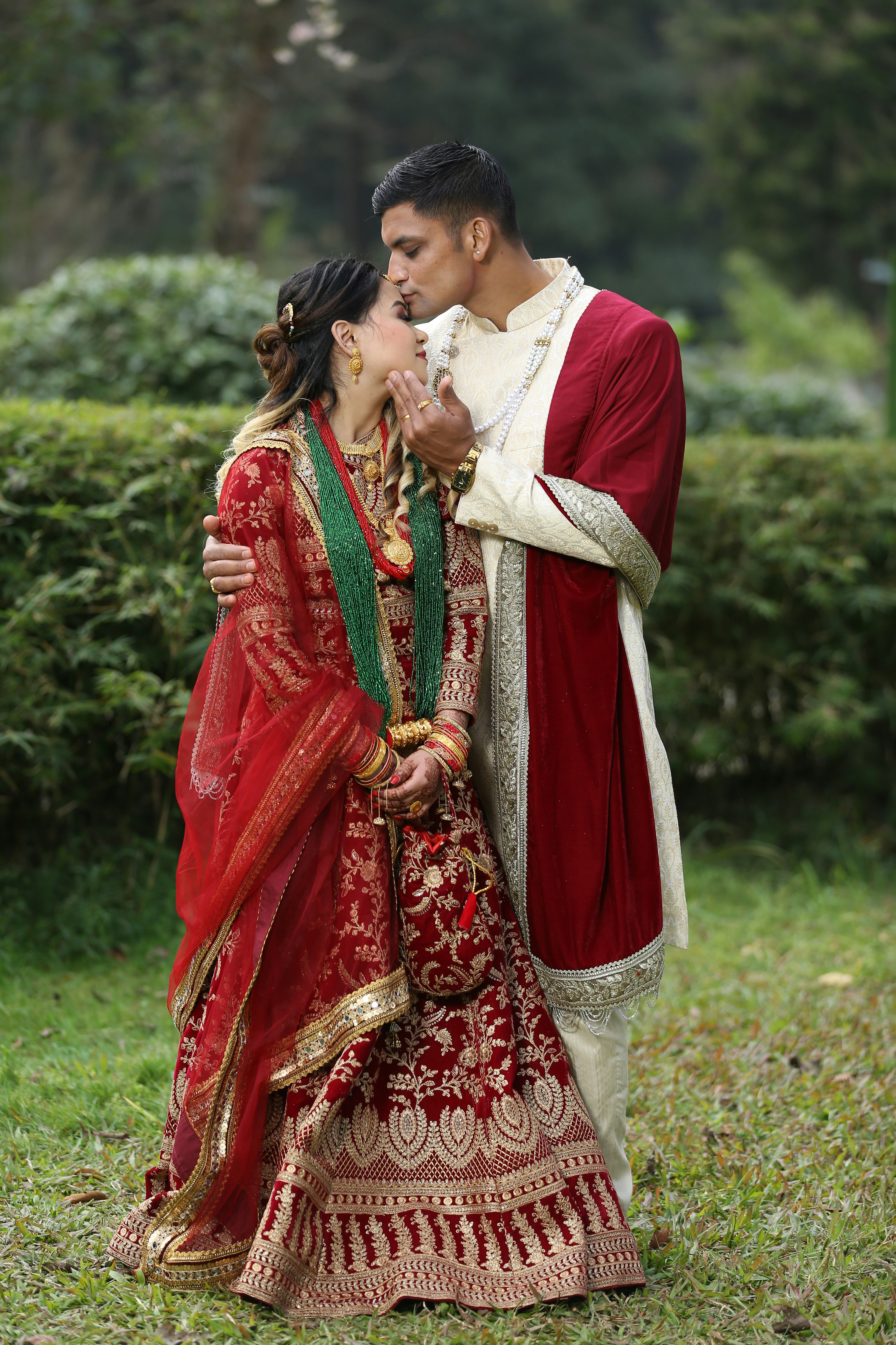 A couple in traditional indian wedding attire embraces outdoors photo ...