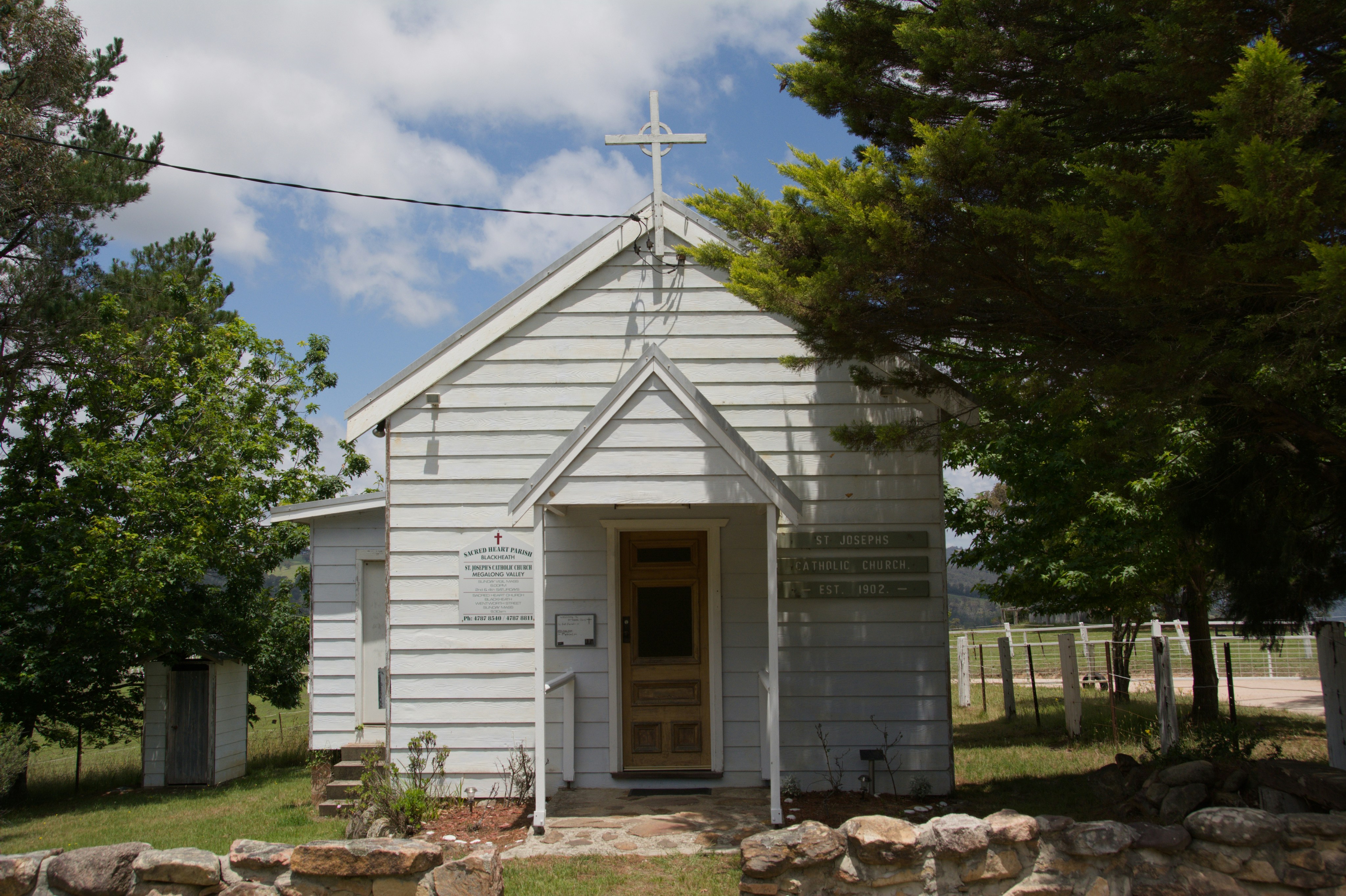 Small white chapel with a cross on top.