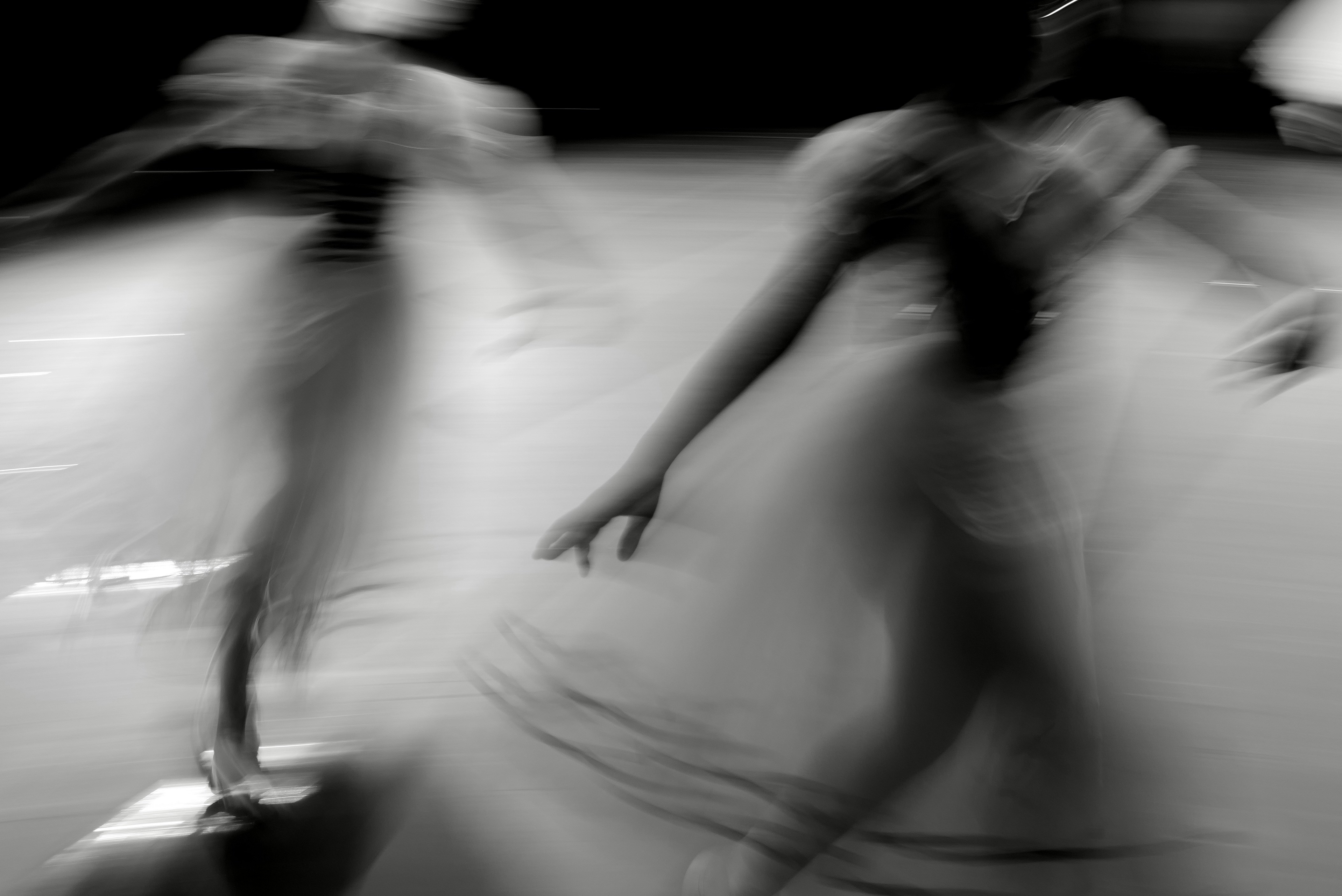 Deux danseurs en mouvement flous sur scène.