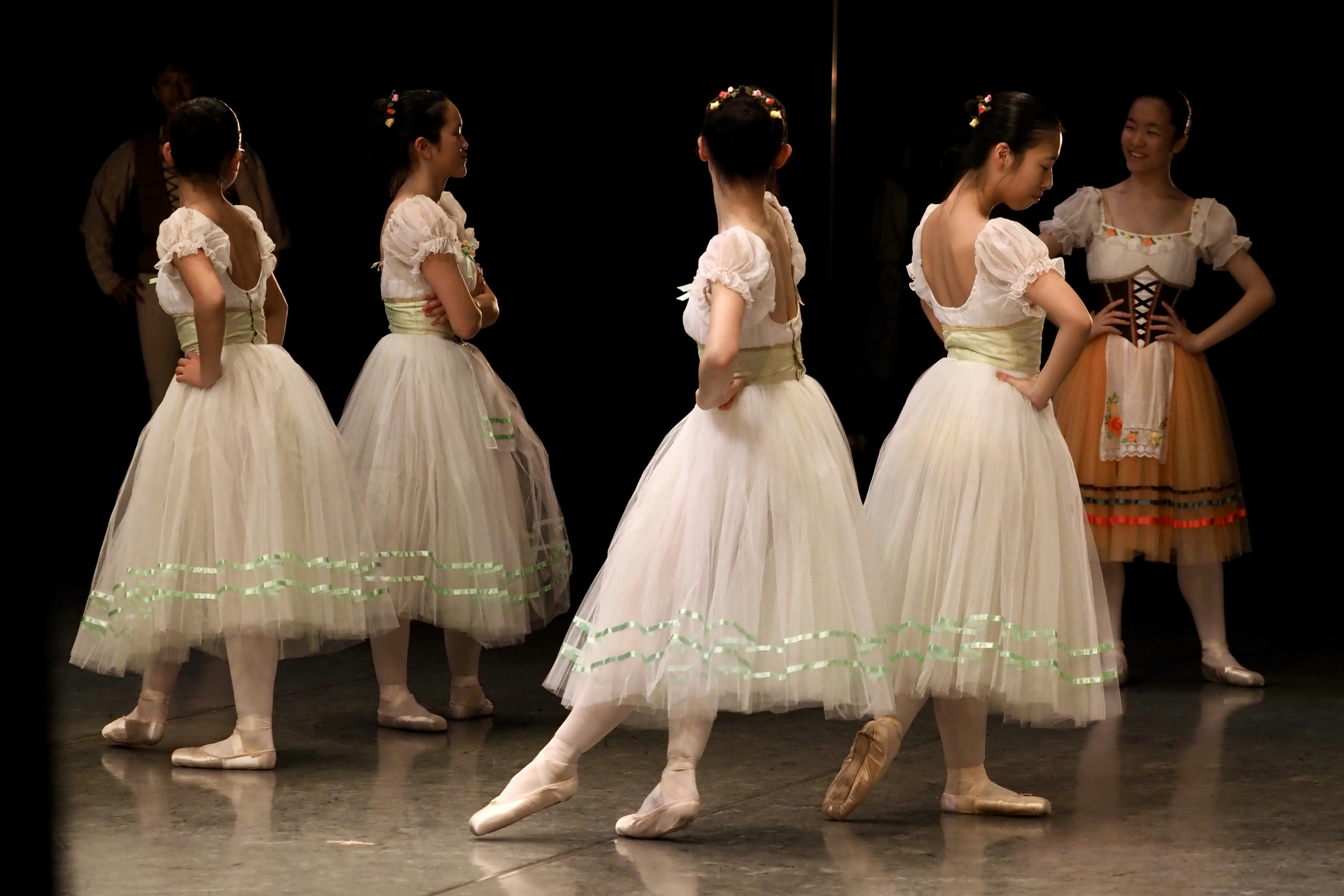 Des danseurs de ballet en tutus blancs sur scène.