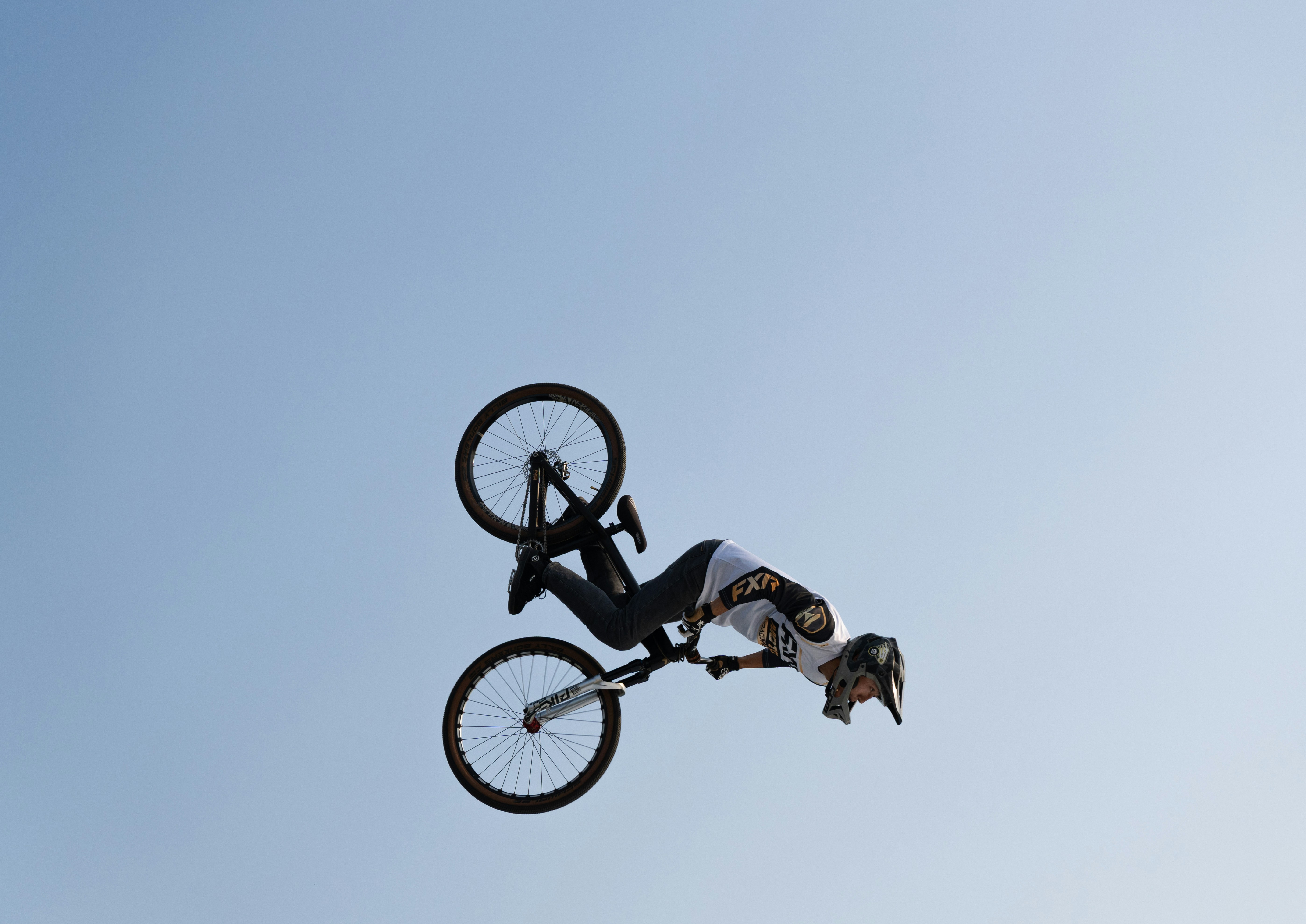 Bmx rider performing a trick against clear sky