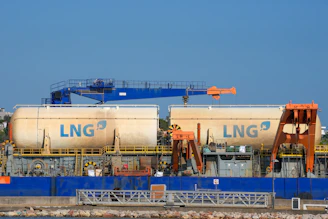 Two large lng tanks on a barge with cranes.