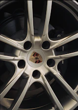 Close-up of a silver porsche wheel with logo