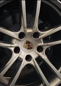 Close-up of a silver porsche wheel with logo
