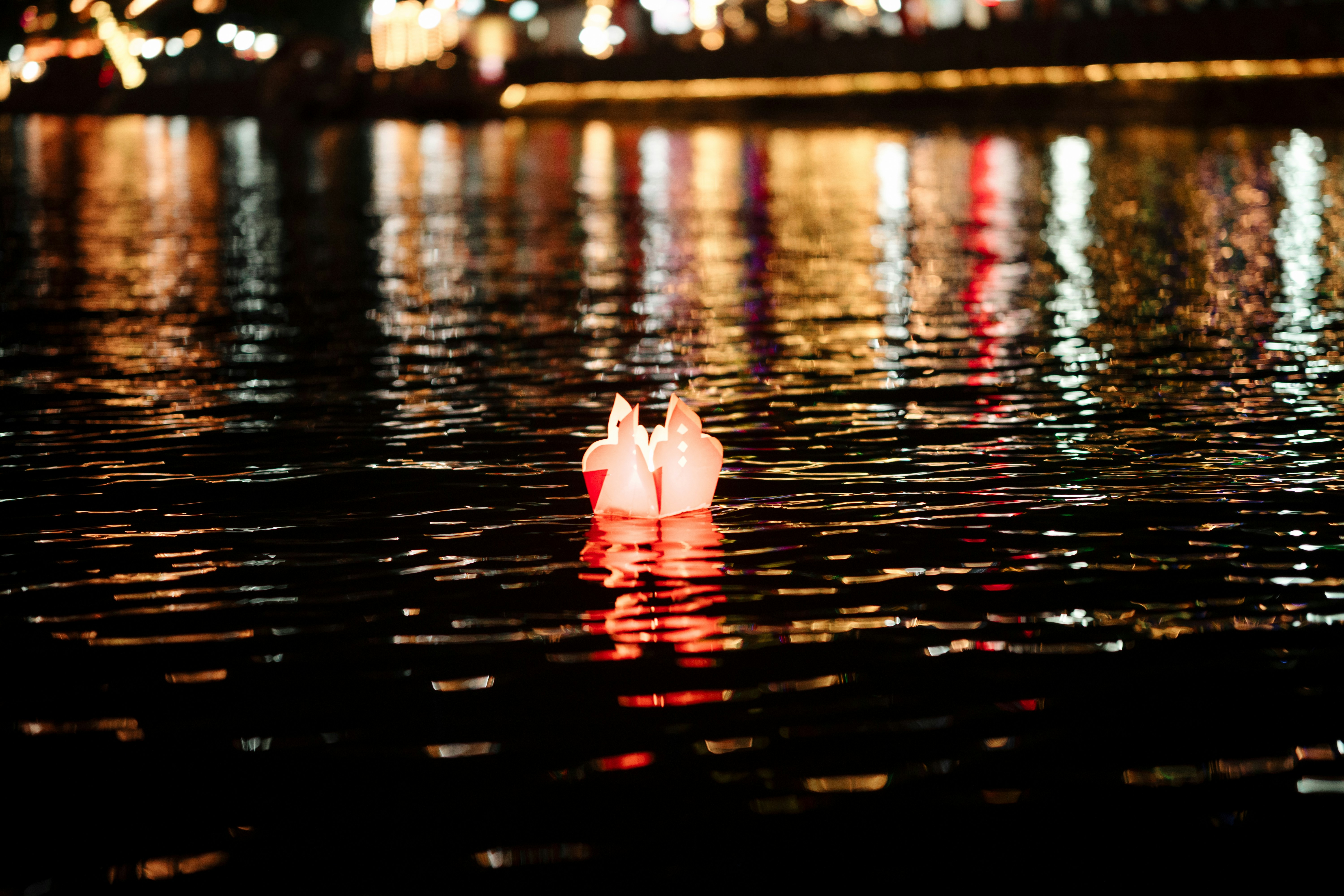 Hoi An full moon lantern festival — paper lanterns floating on the Thu Bon River at night