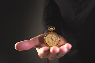 A person holding a vintage pocket watch in their palm.