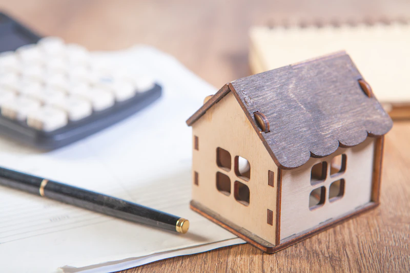 Model house with calculator representing Rise Credit flexible payment scheduling
