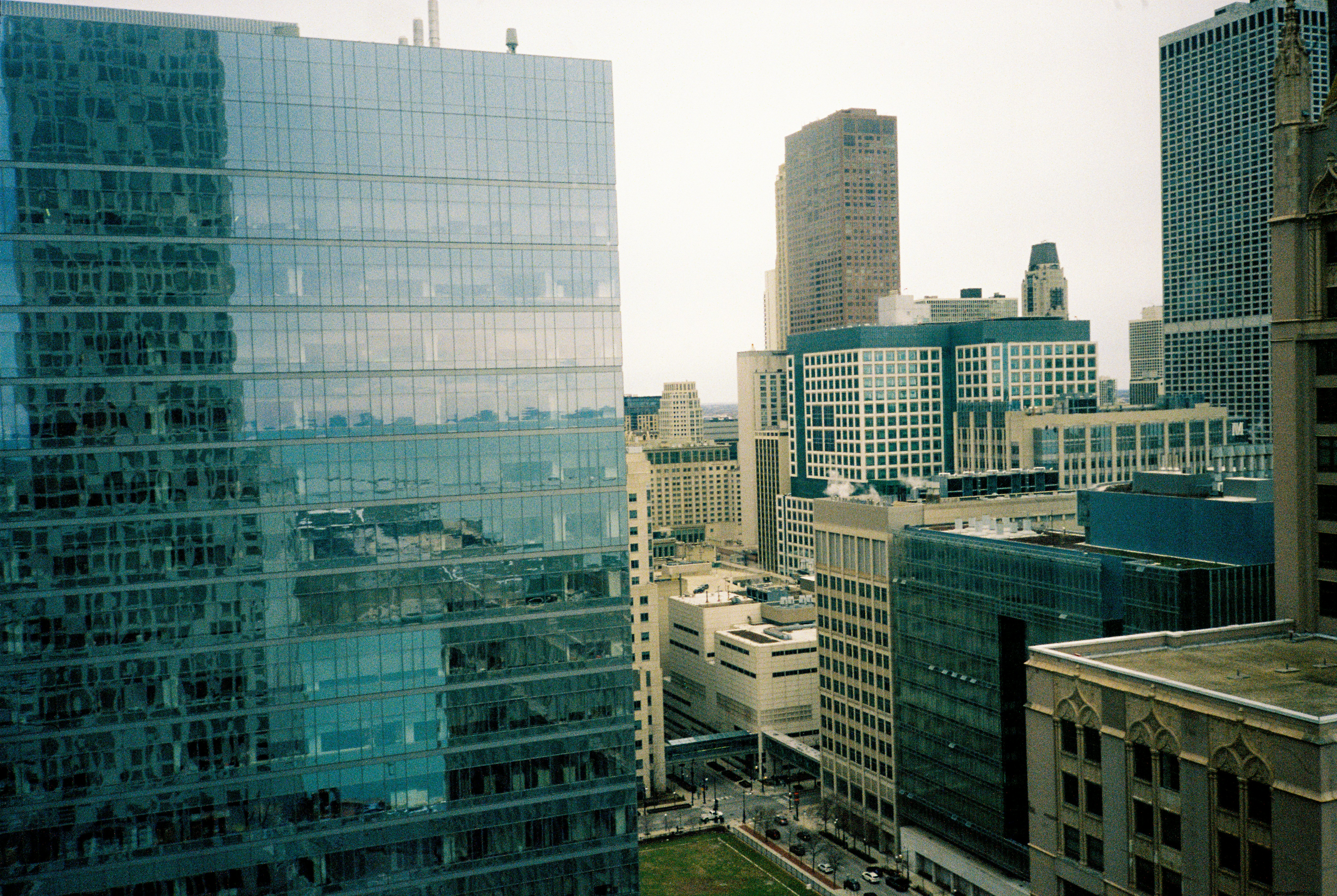 Modern glass building reflecting city skyline and skyscrapers.