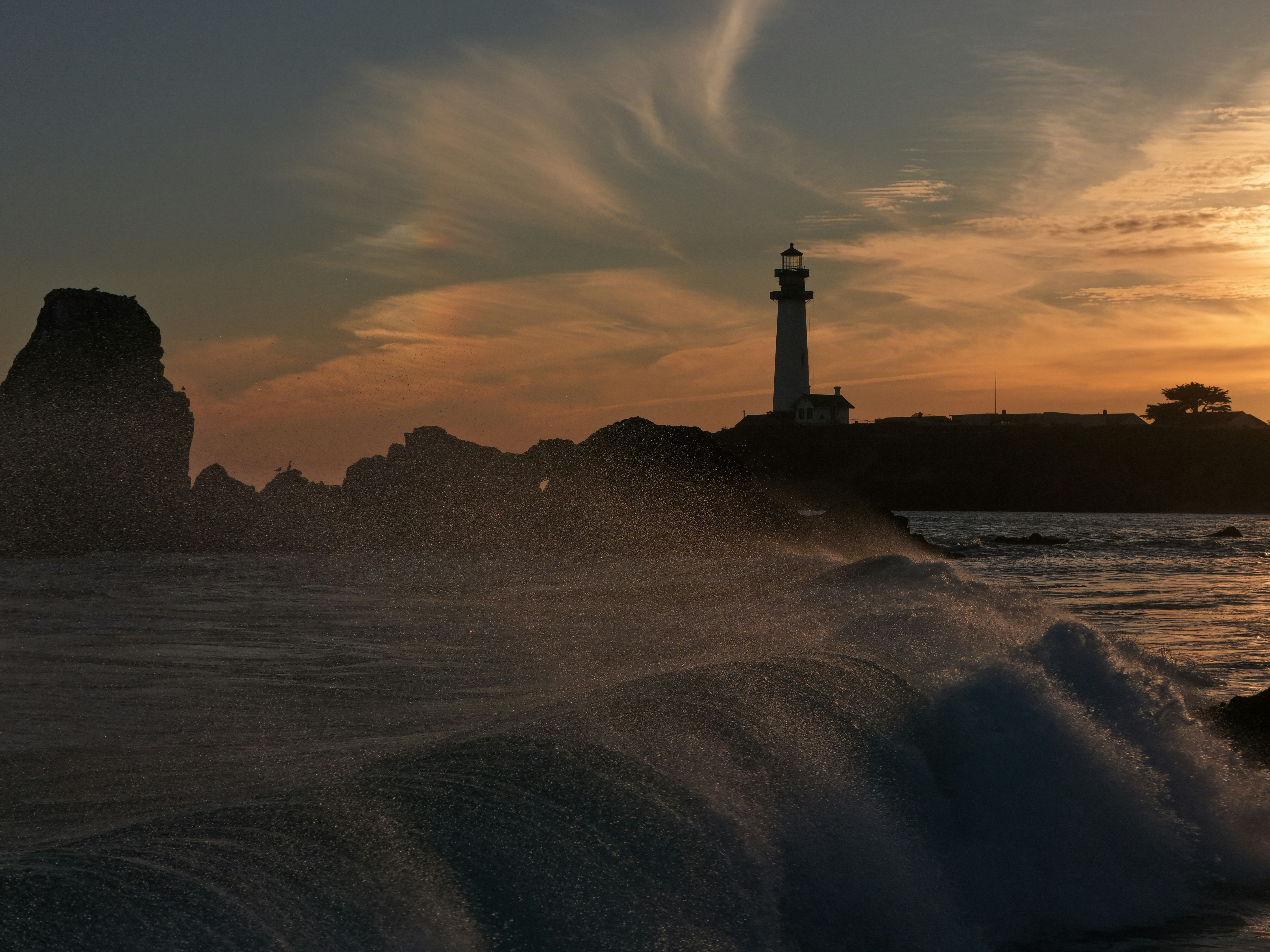 Faro en una costa rocosa al atardecer