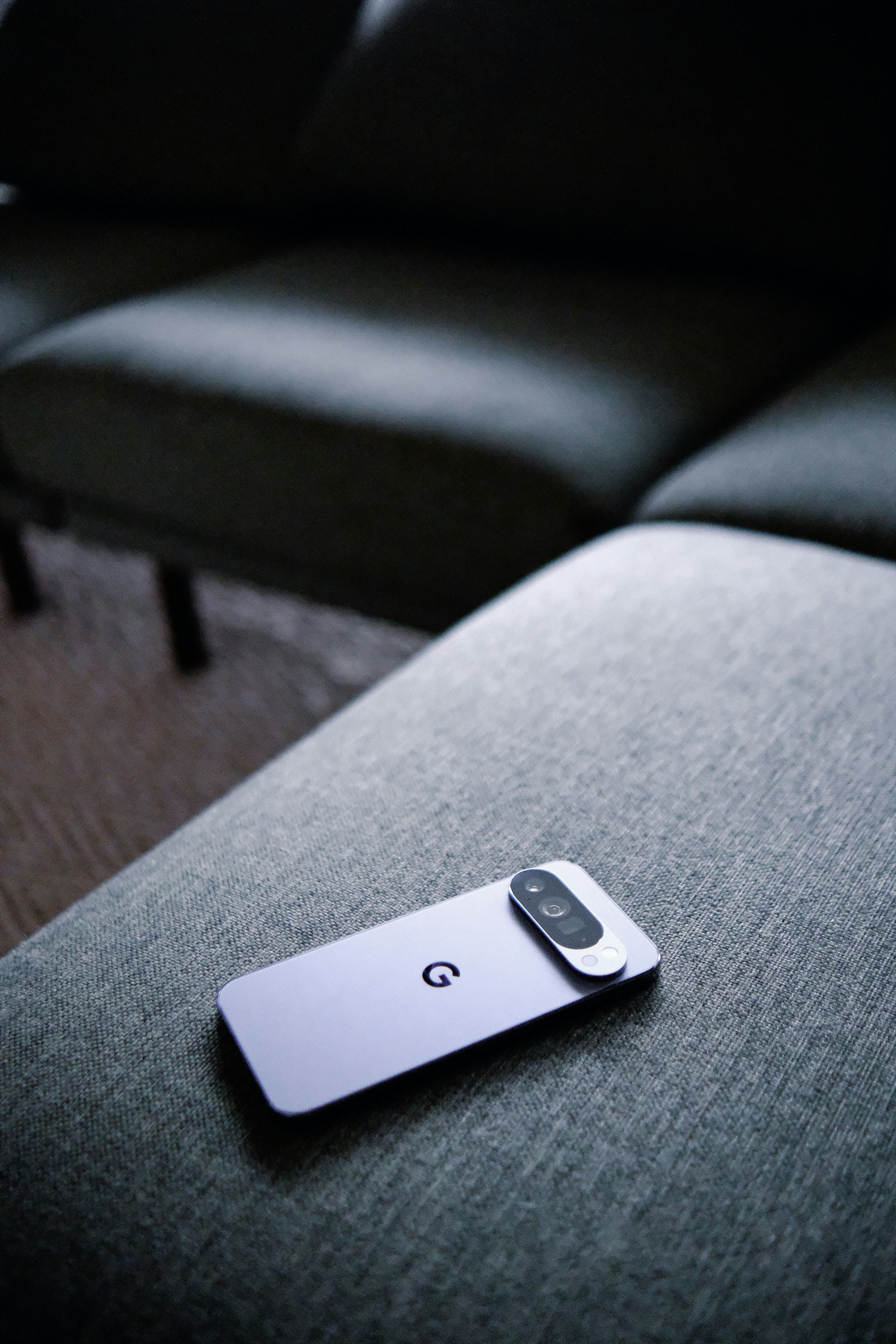 Smartphone modern bertumpu di sofa bertekstur.