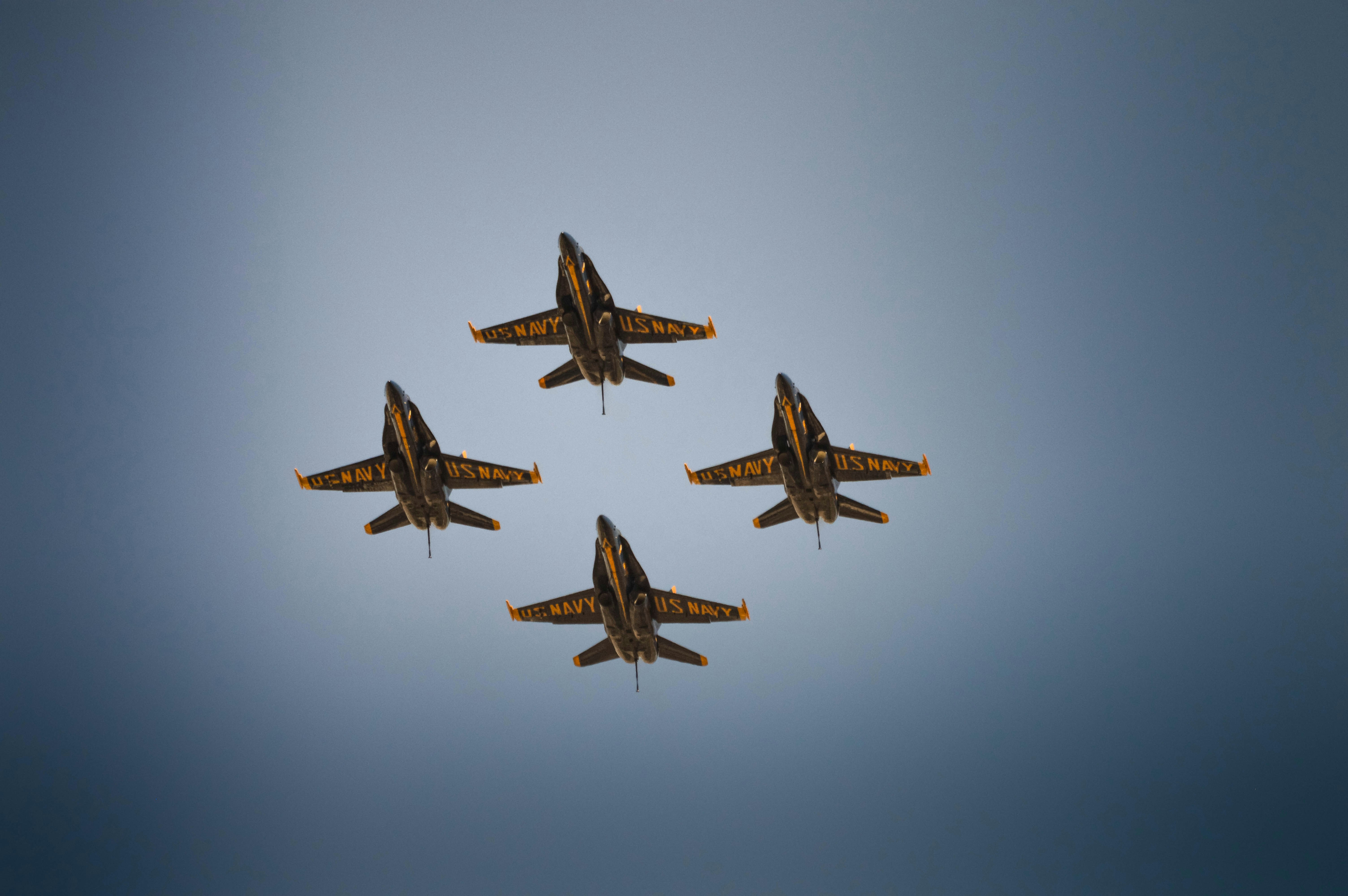 Four fighter jets flying in formation against a blue sky