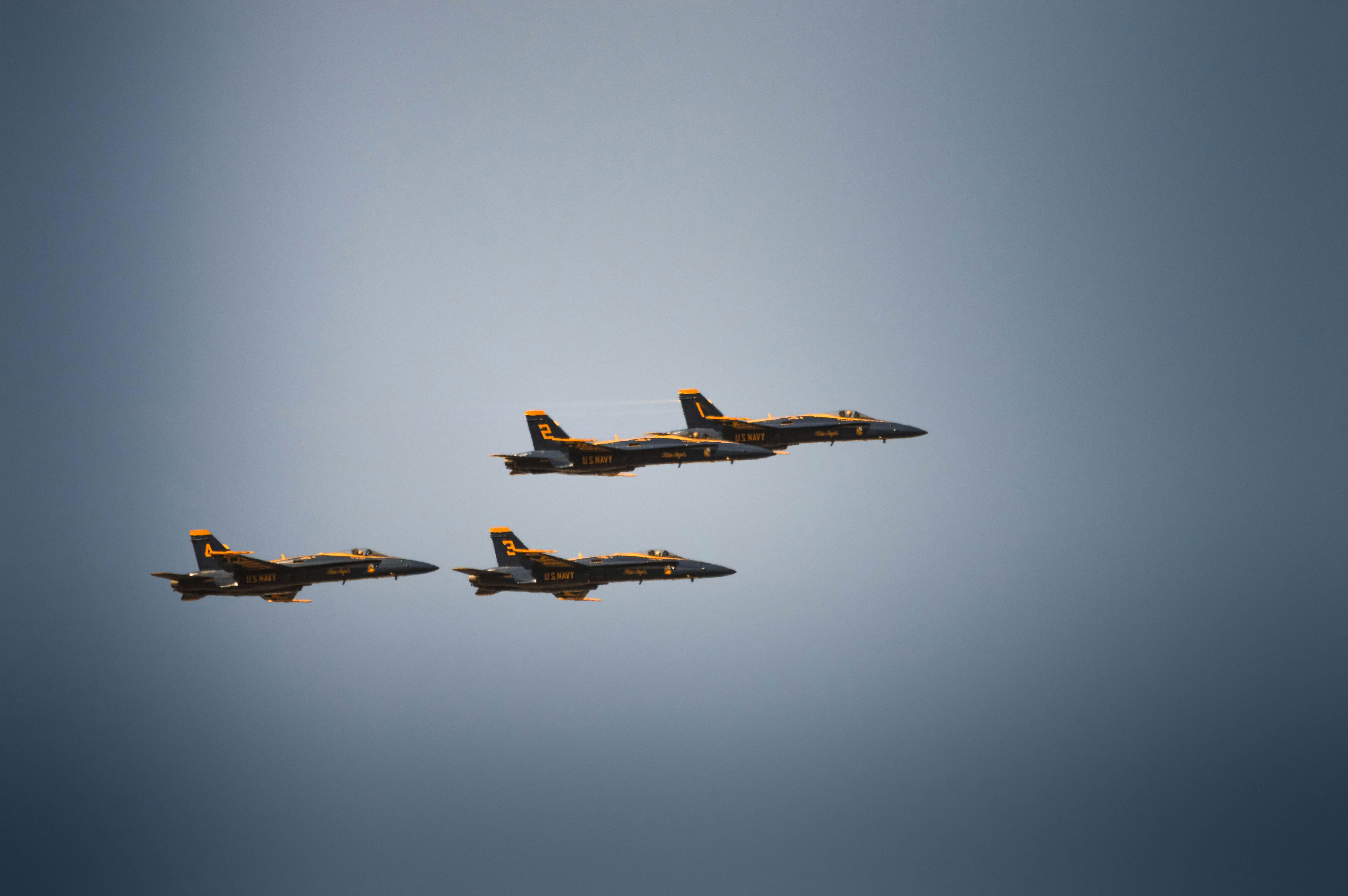 Three fighter jets flying in formation against a cloudy sky.