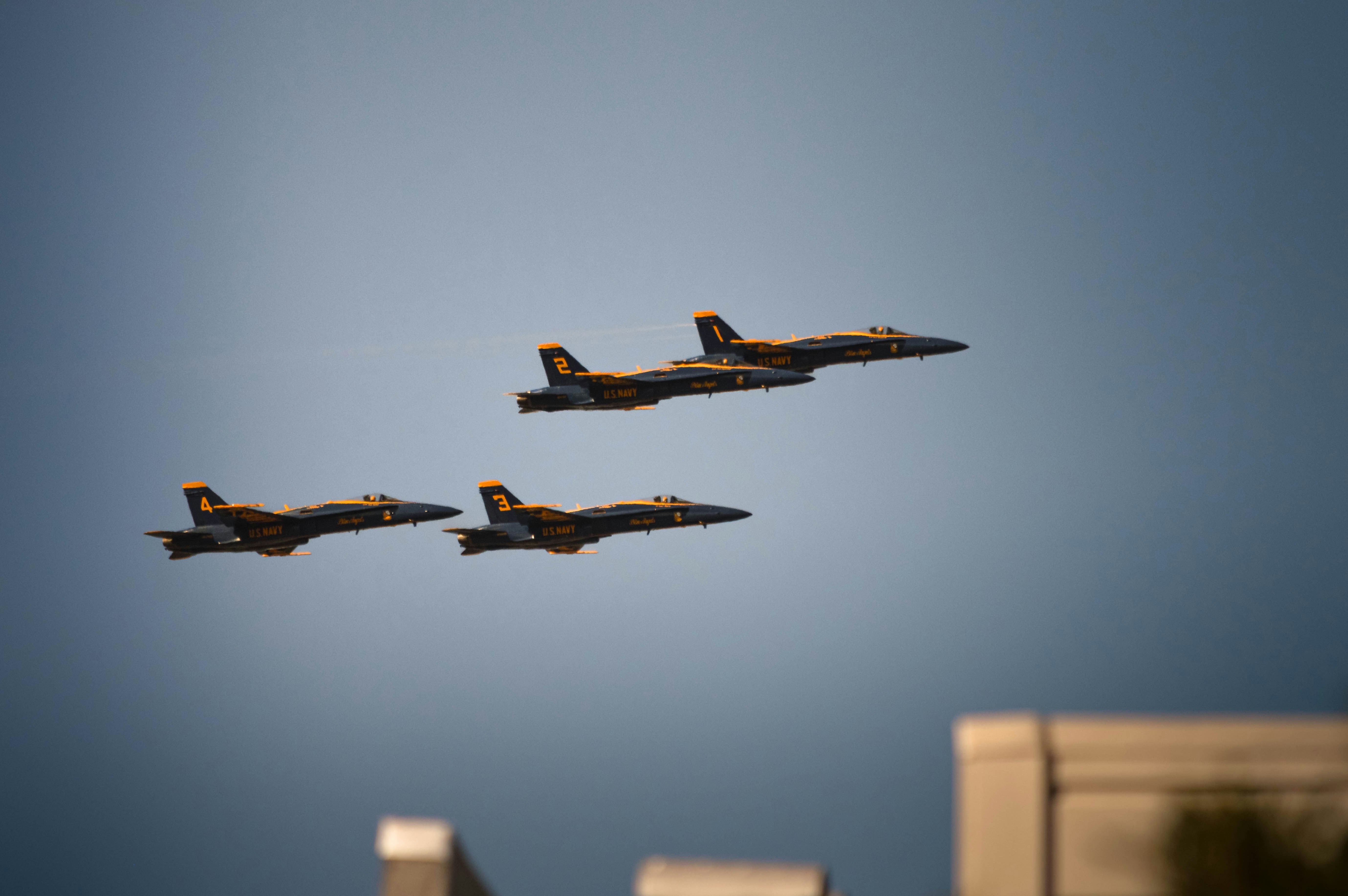 Three fighter jets flying in formation against a blue sky.