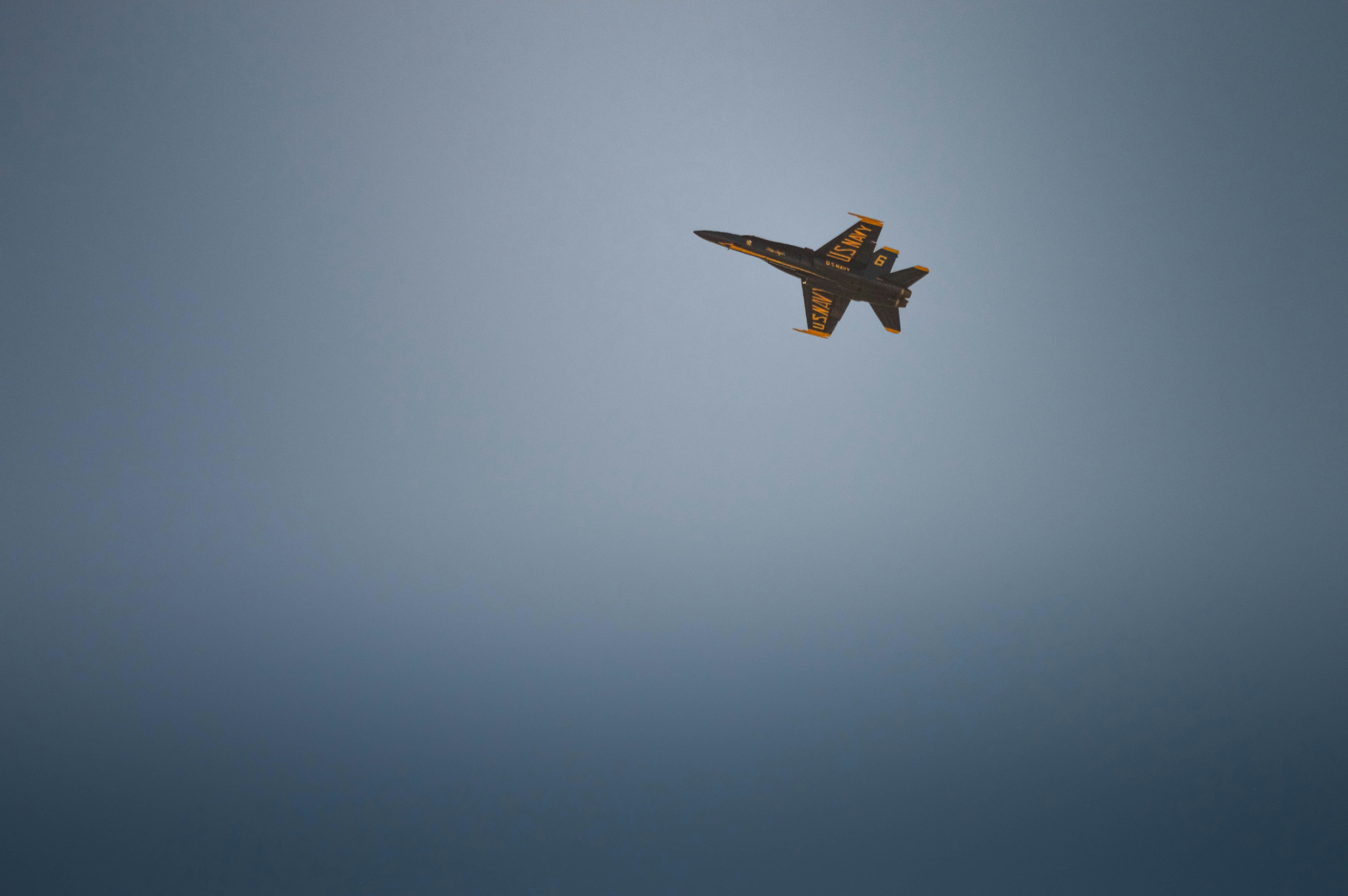 A fighter jet flies in a clear blue sky.
