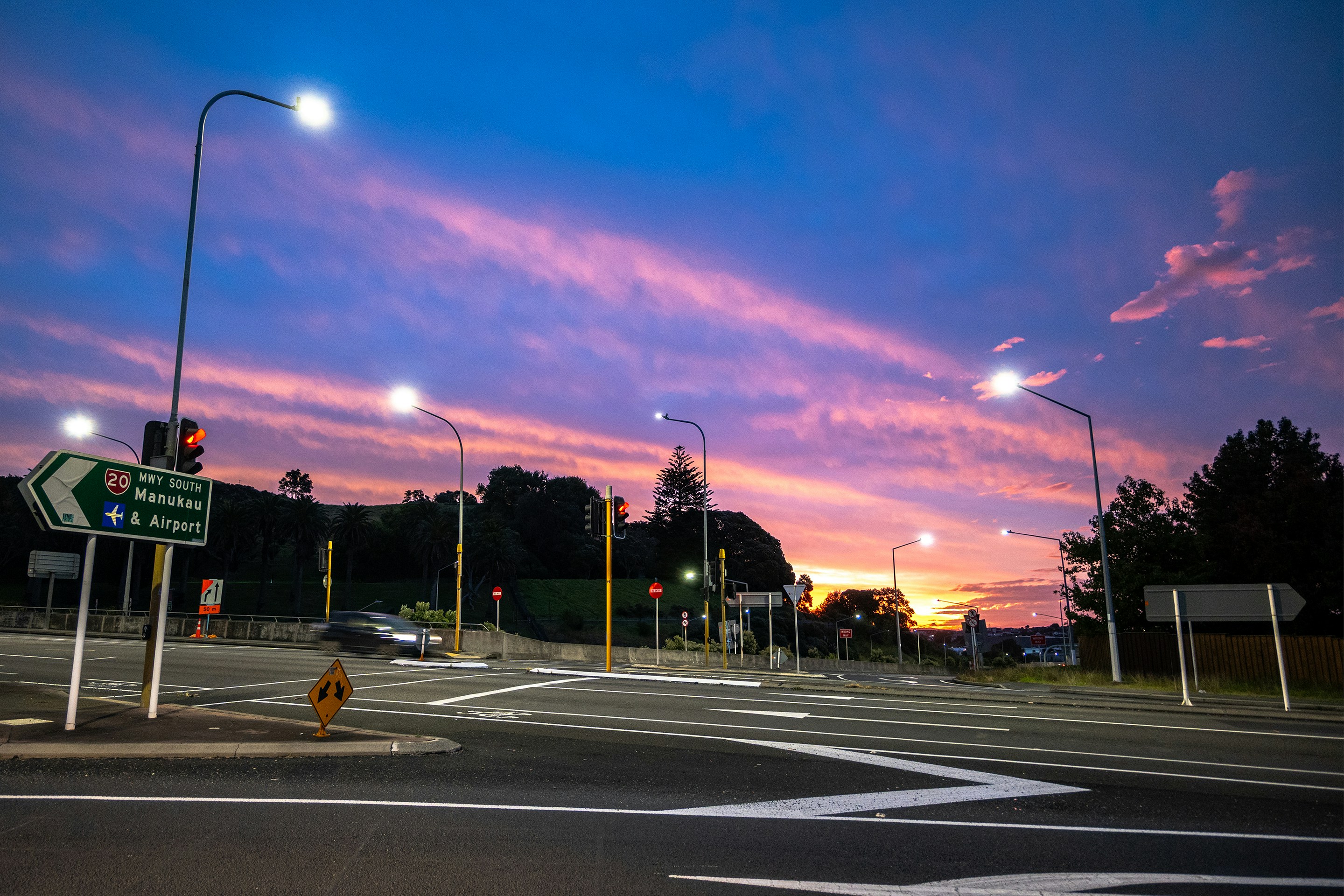 Empty intersection under a vibrant sunset sky