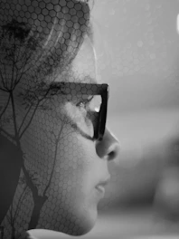 Double exposure of a woman's face and tree branches.