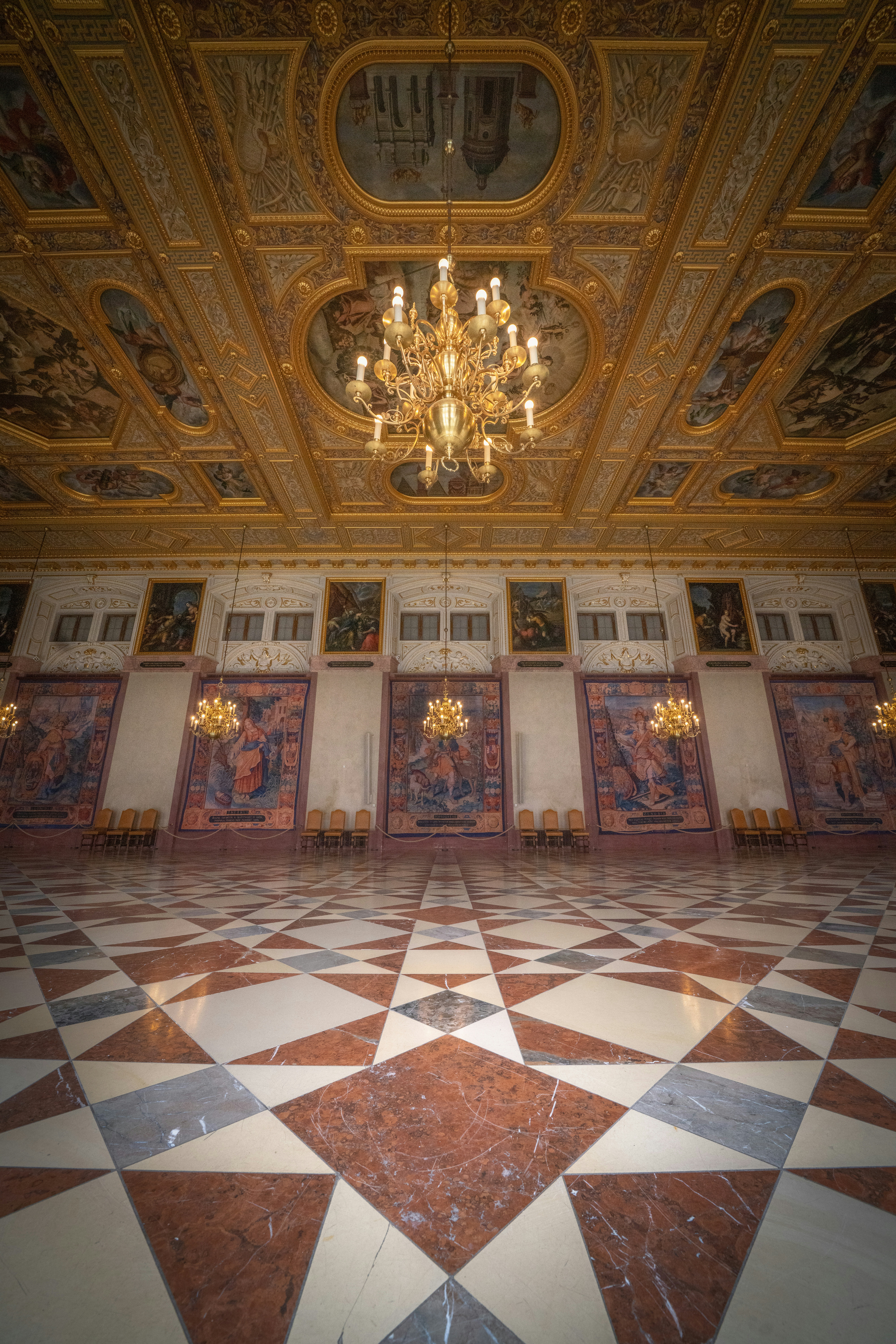 Ornate hall with patterned floor and chandeliers