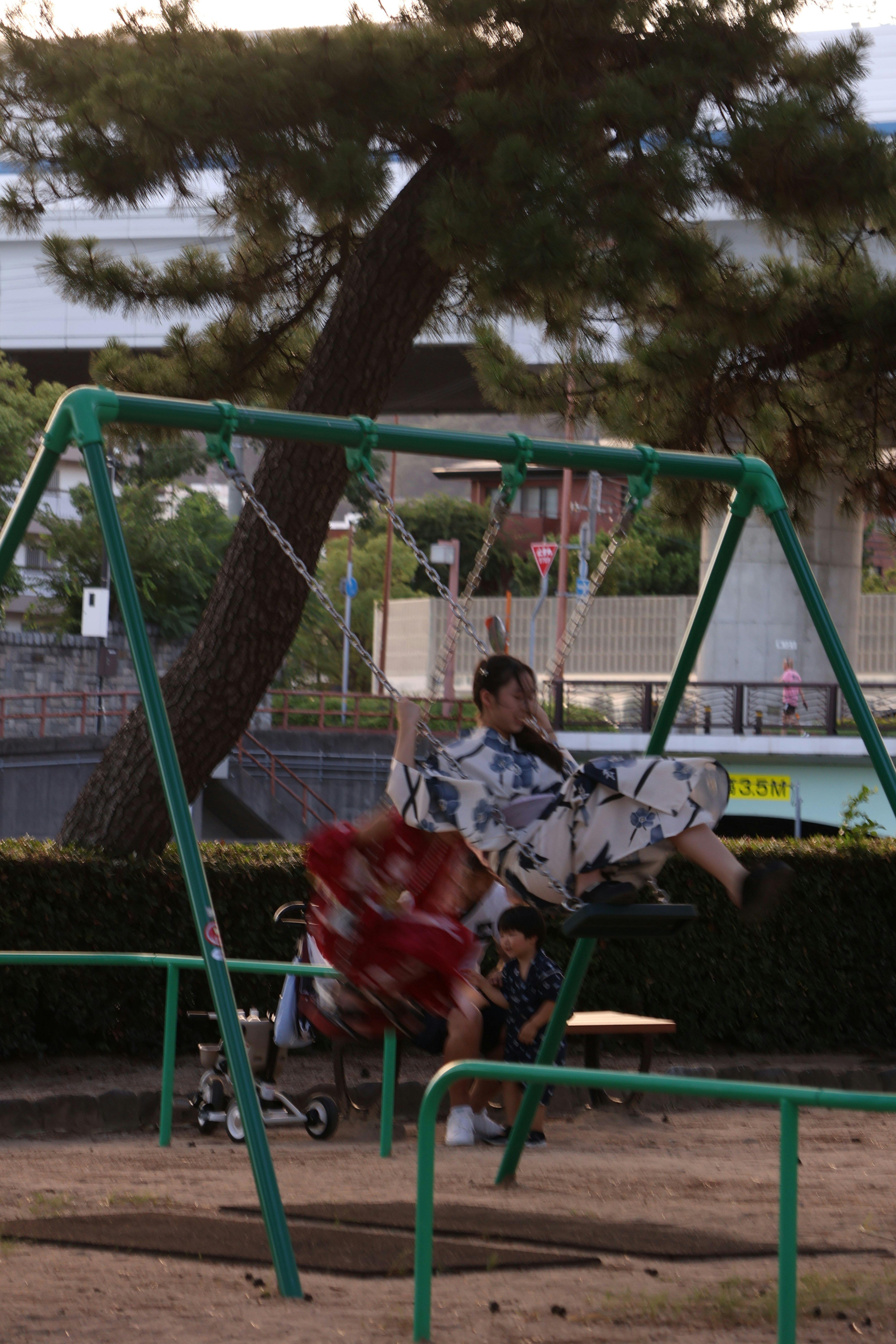 People in yukatas swinging on a playground