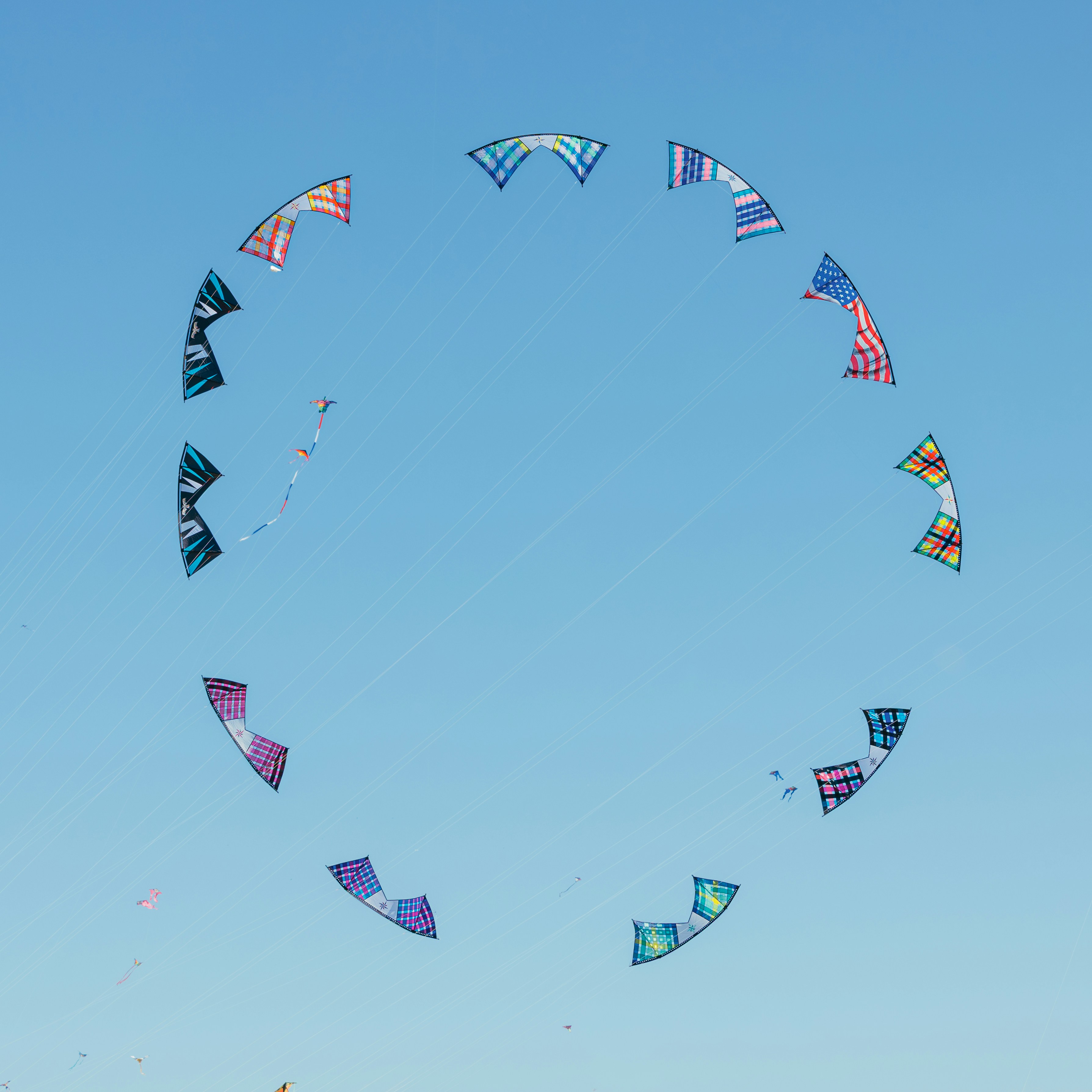 Kites arranged in a circle against a blue sky