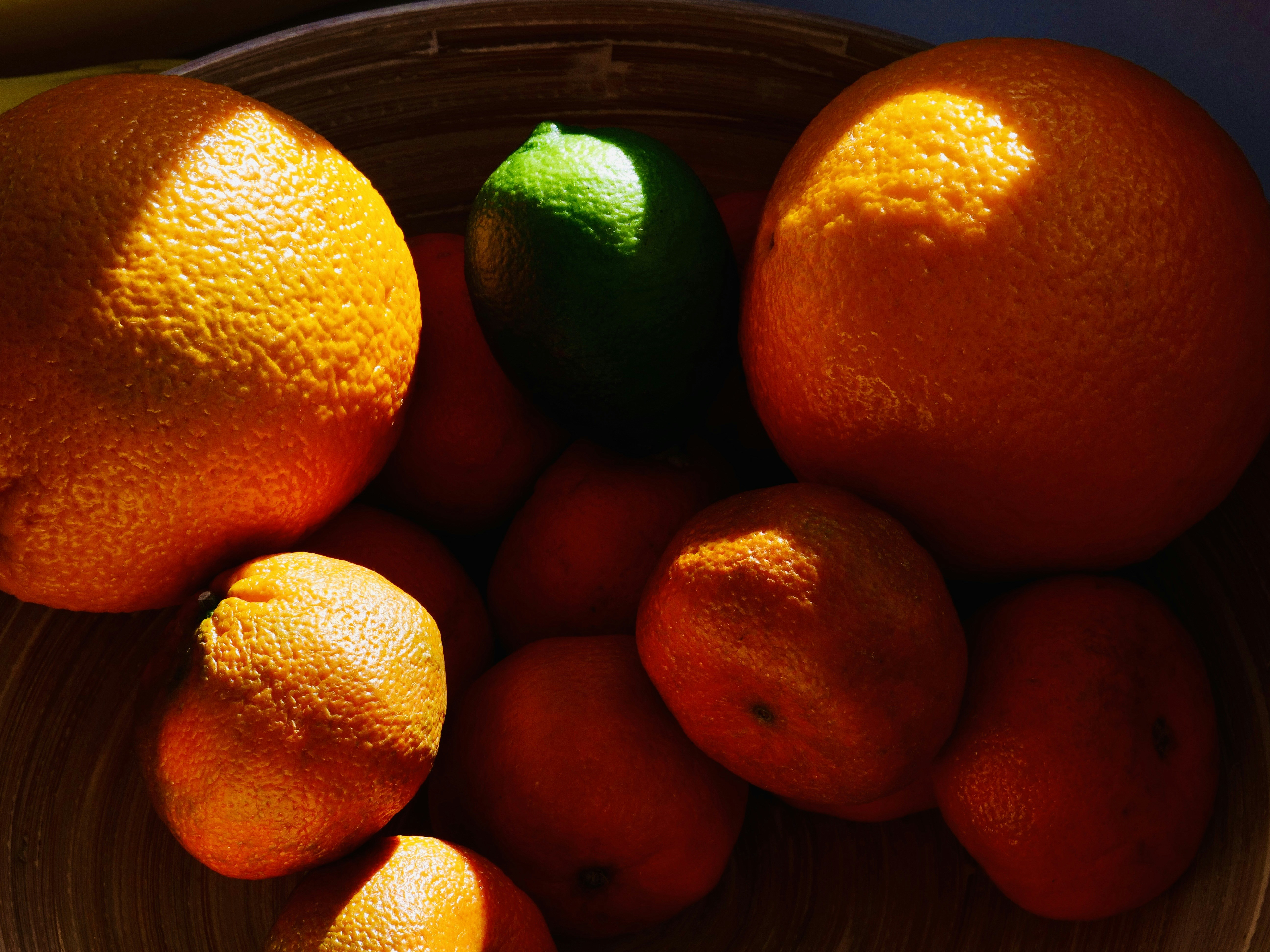 ボウルにオレンジと緑のライムが一つ