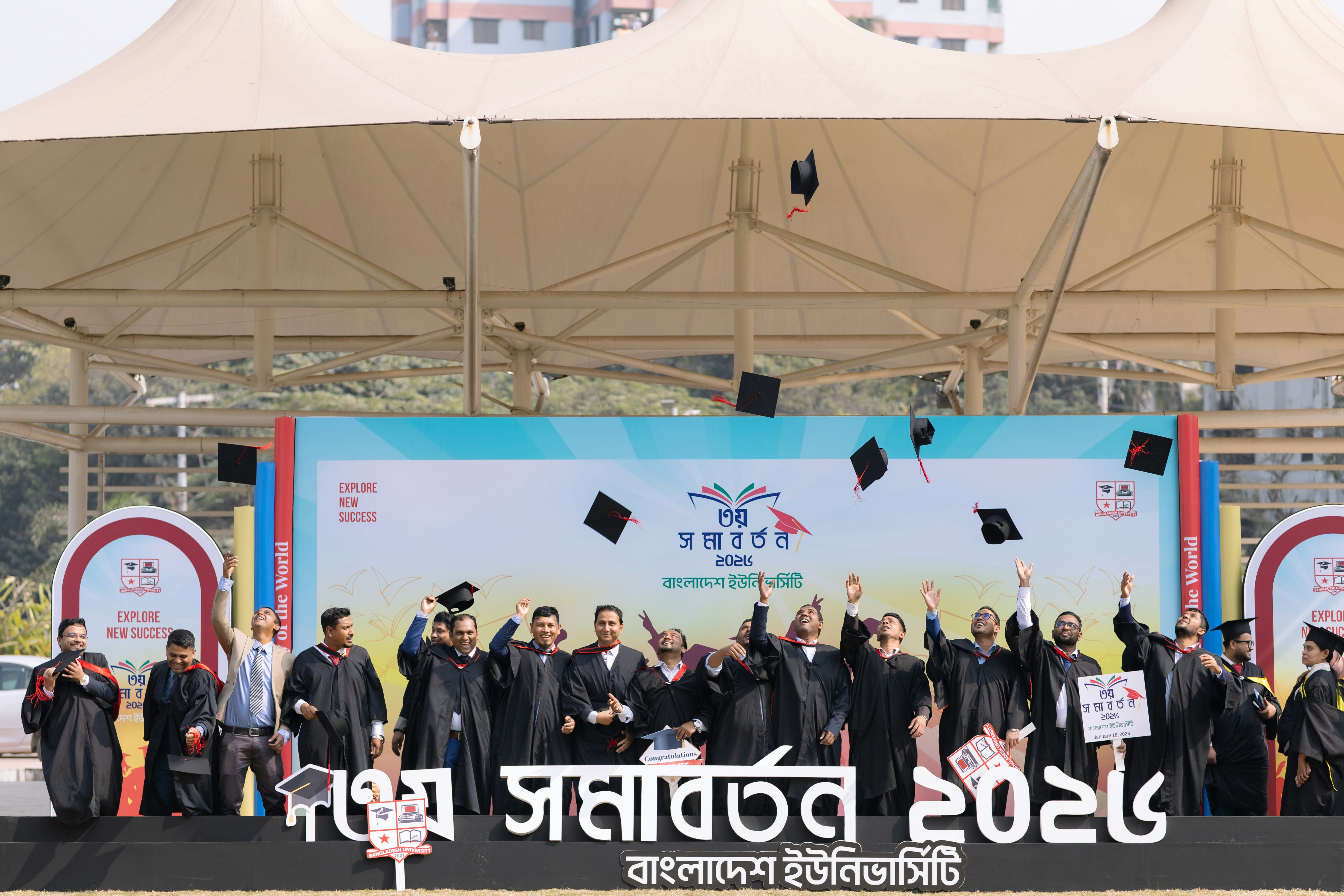 Absolventen werfen bei einer Zeremonie Mützen in die Luft