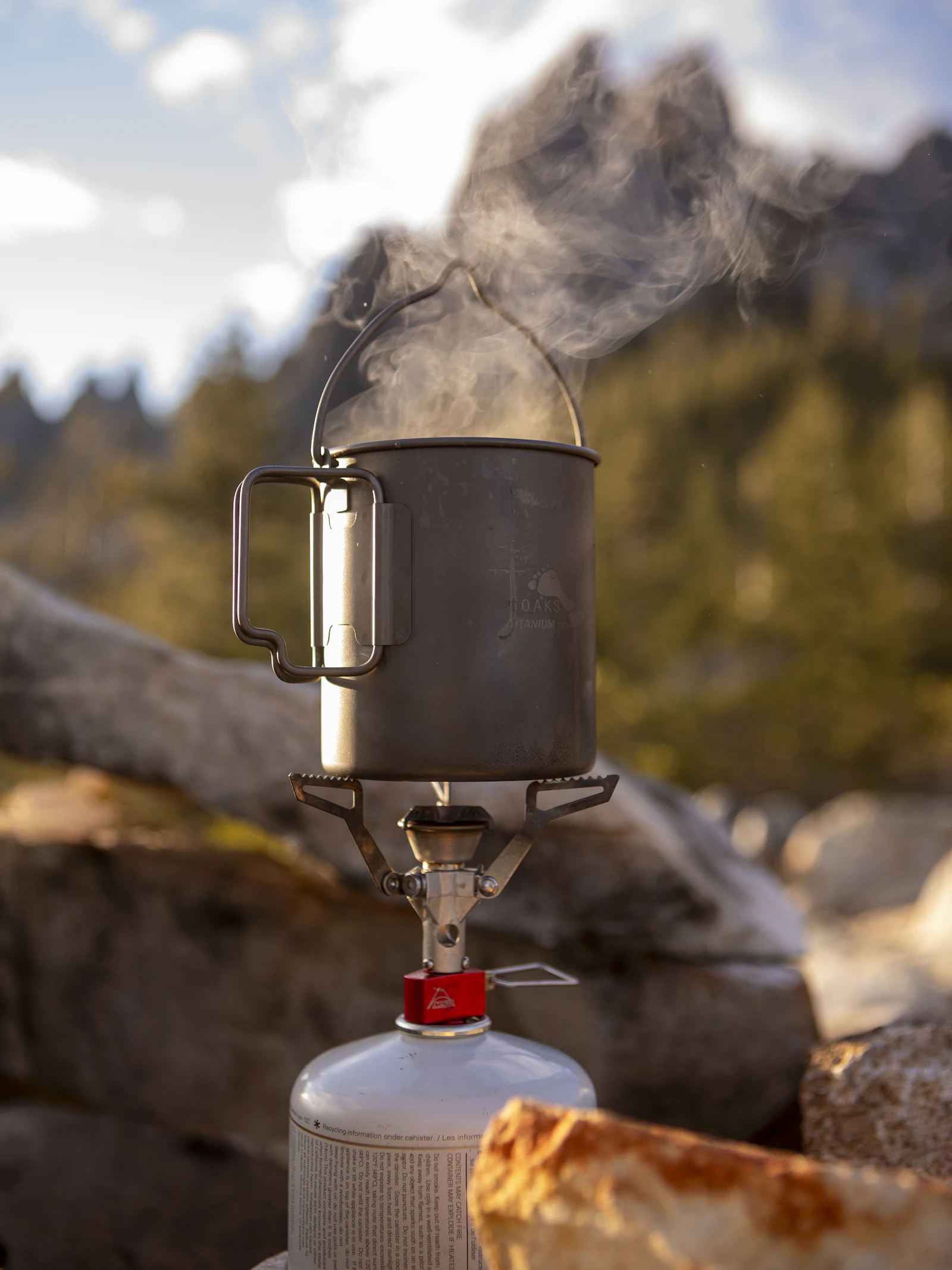 Portable camping stove and cookware being used at an outdoor campsite