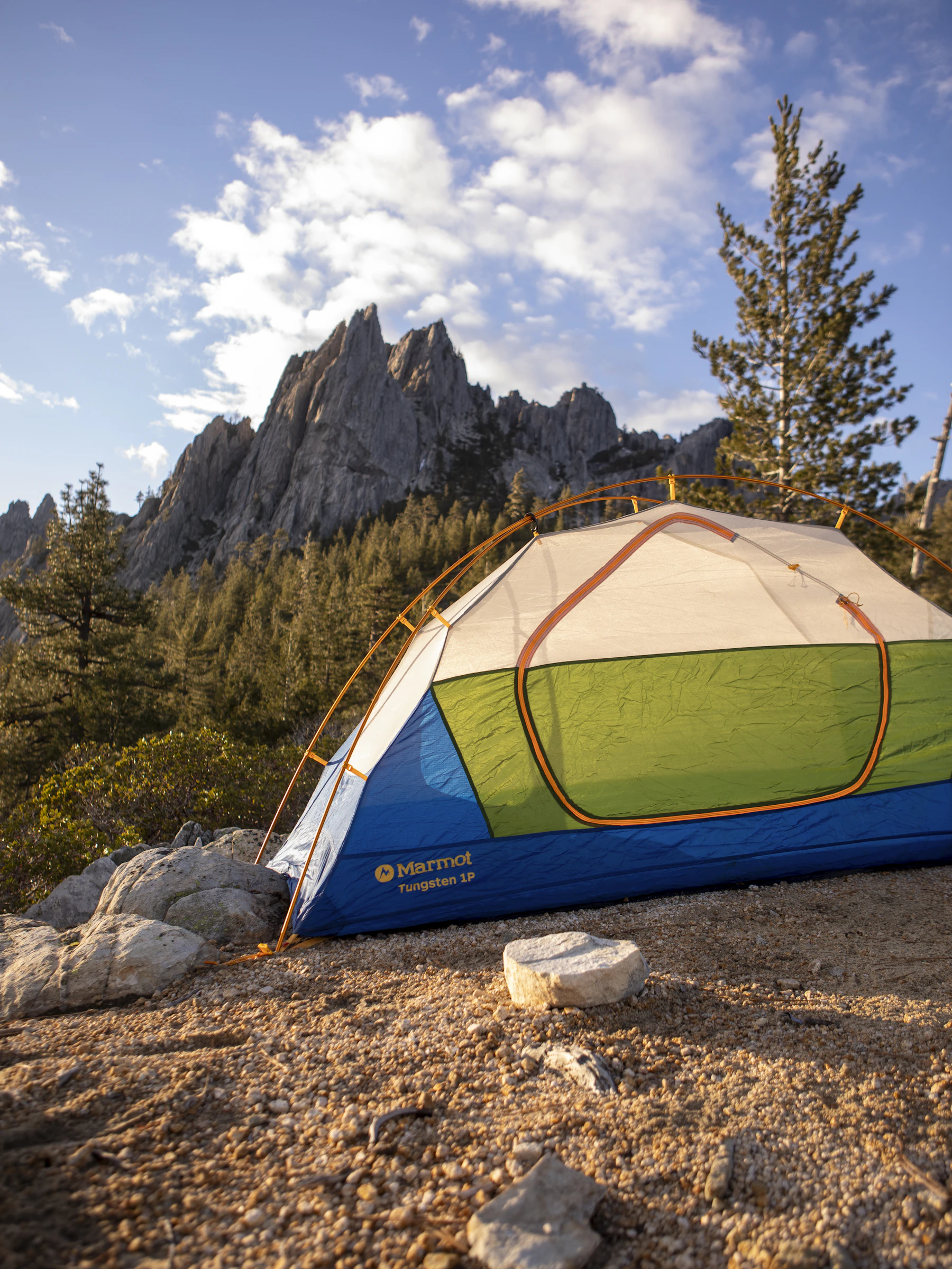 Camping tent set up among rocky mountains at an outdoor campsite