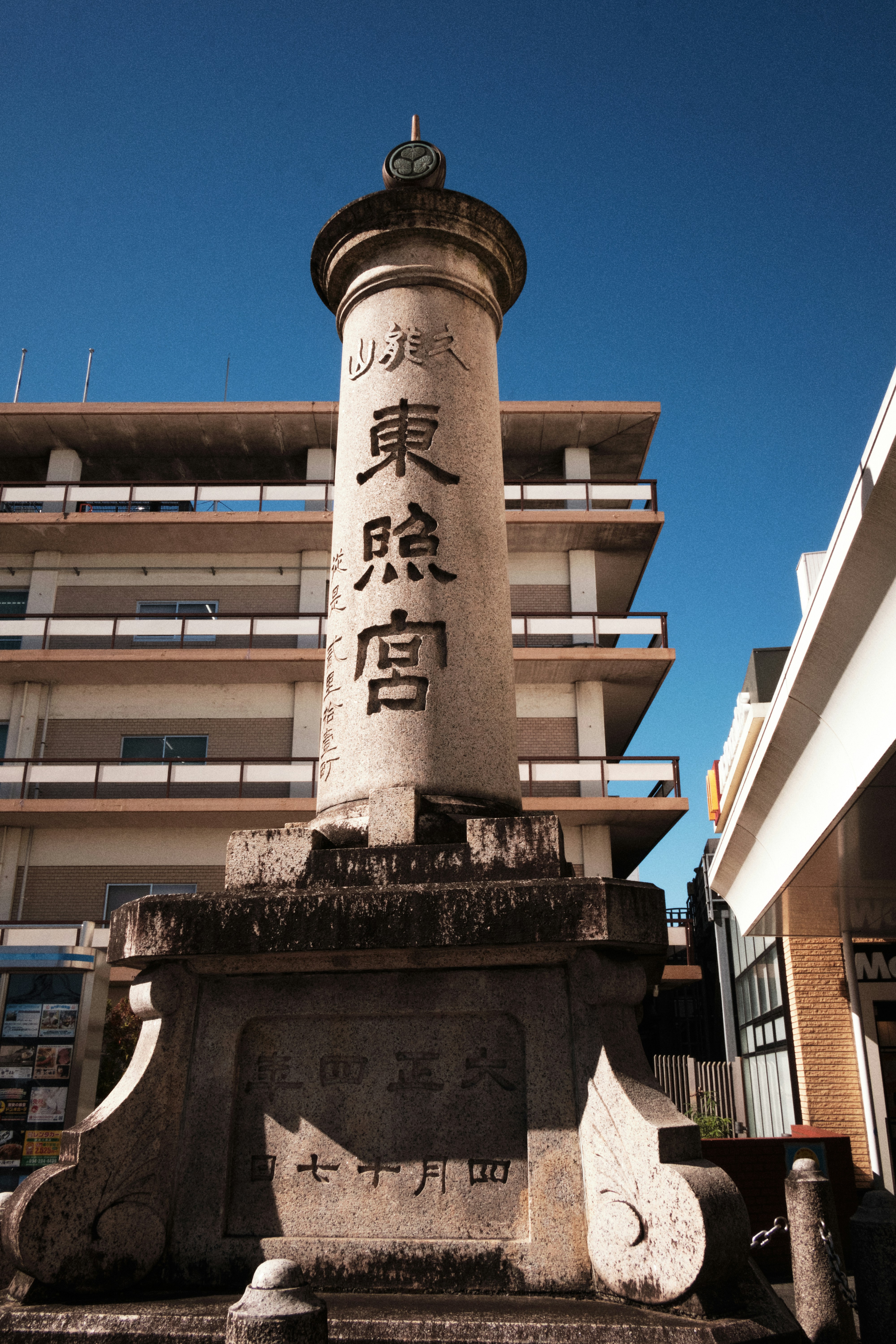 Stone monument with japanese writing against blue sky