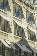Row of arched windows with awnings on building