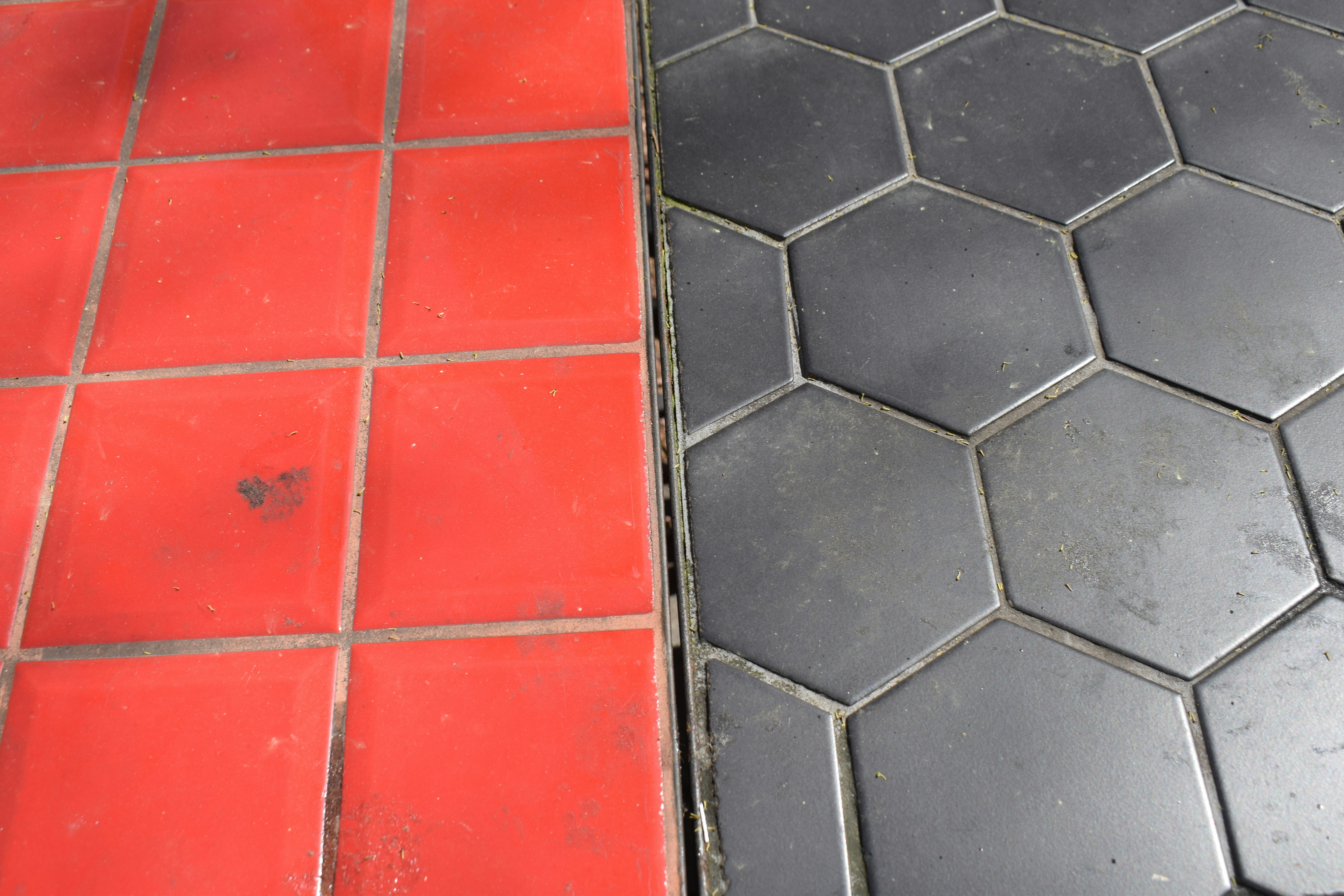 Red square tiles meet black hexagonal tiles