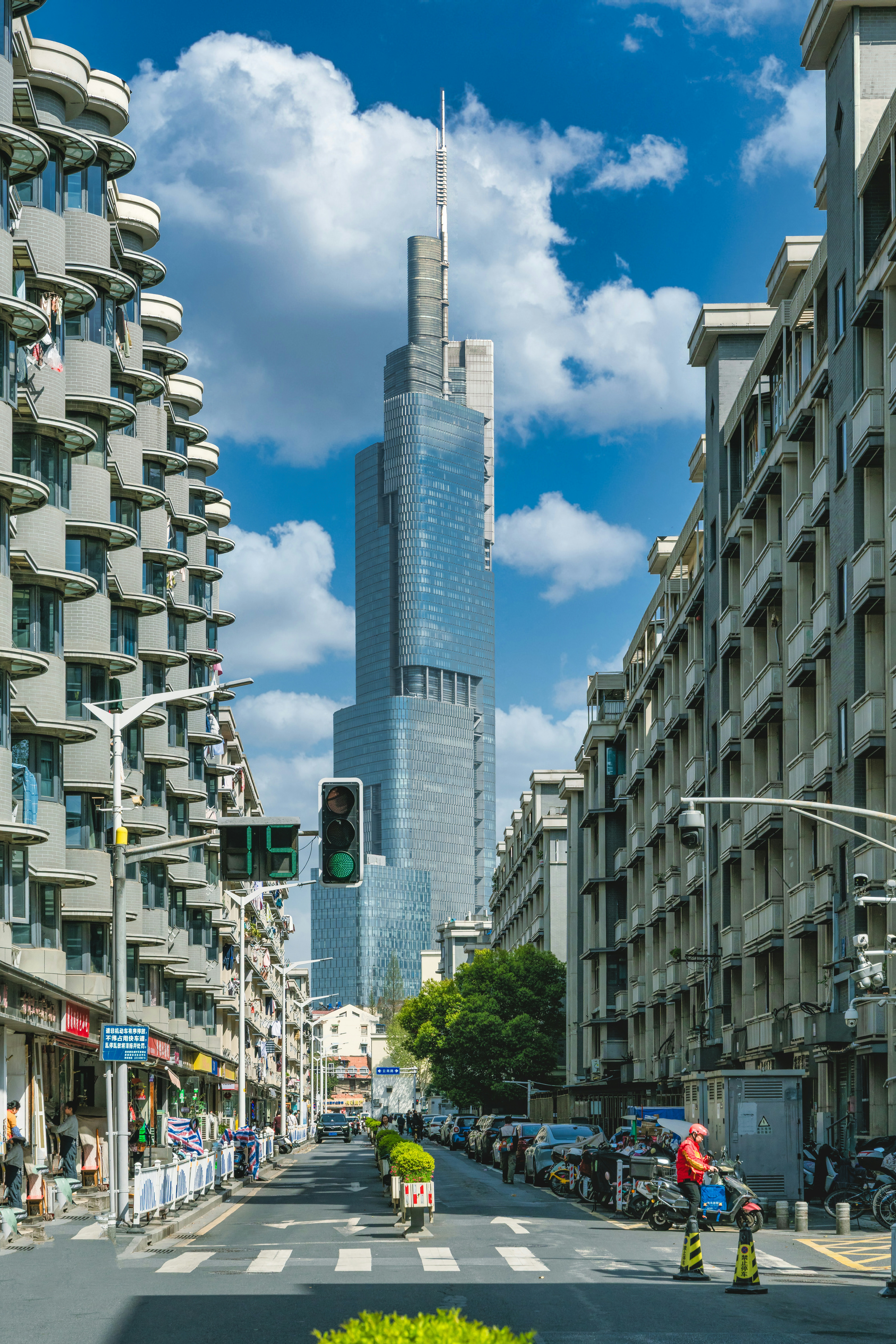 Tall skyscraper dominates a city street with buildings.
