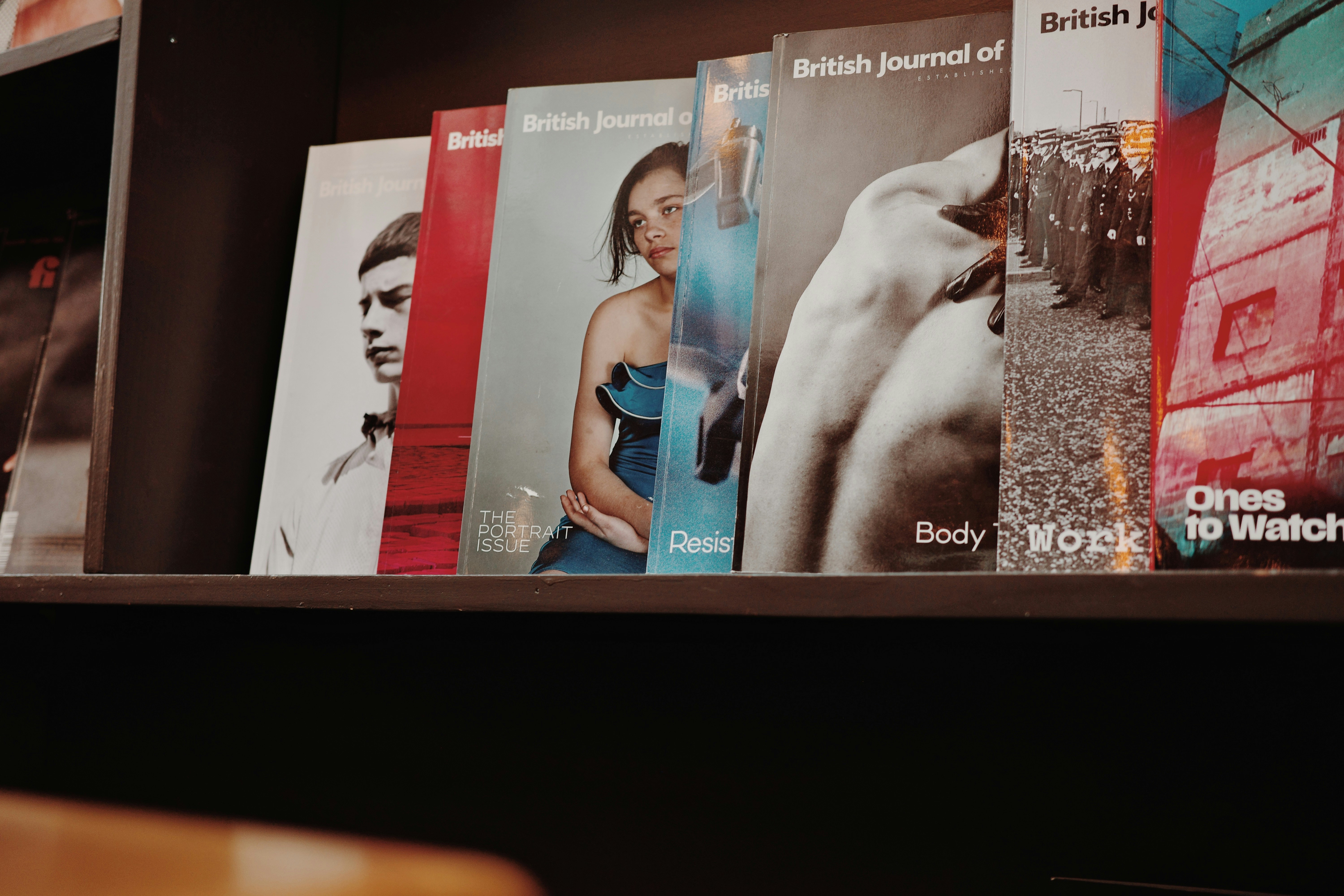 Magazines on a bookshelf with various covers.
