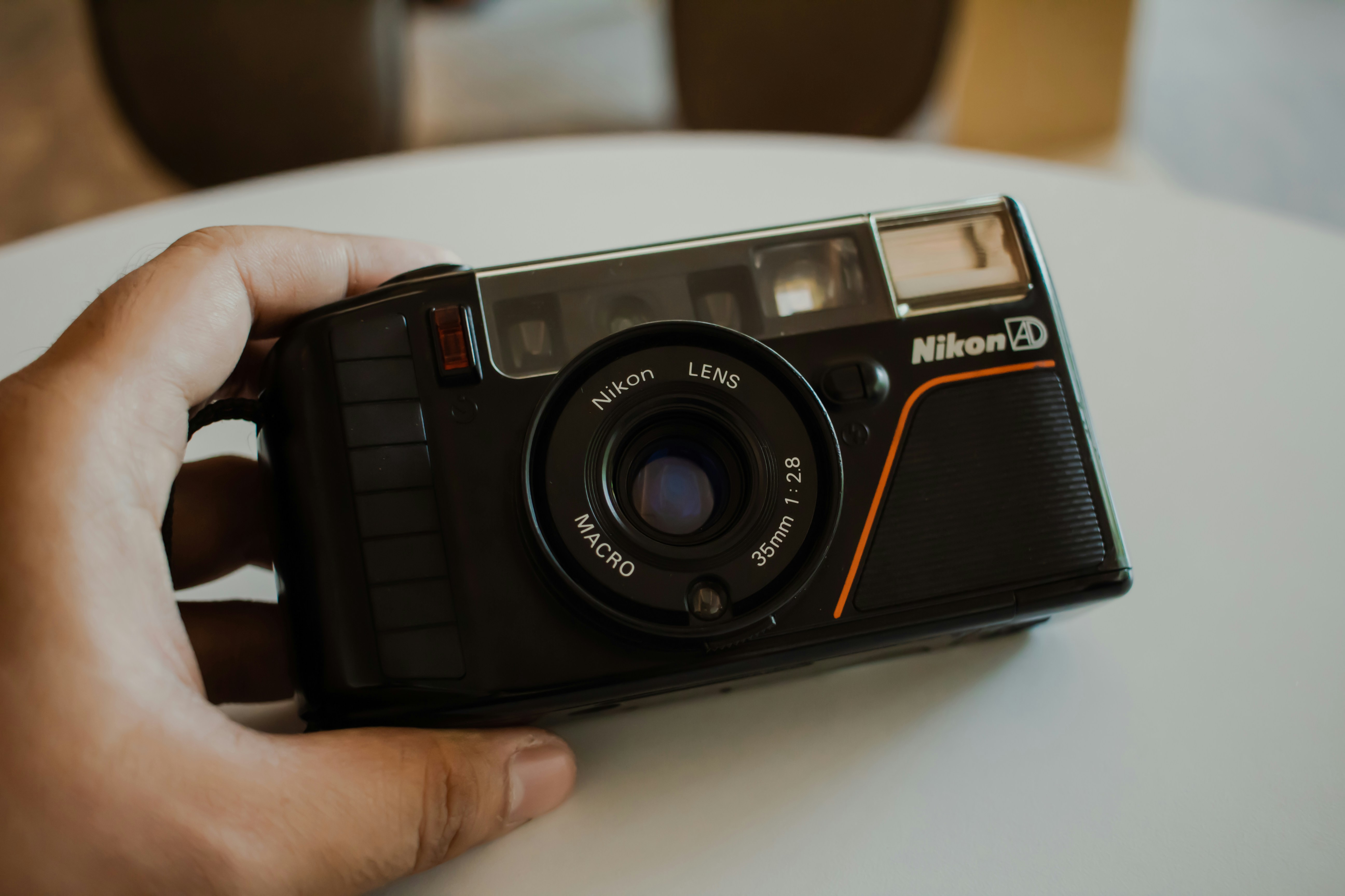 黒いニコンのコンパクトカメラを手に持っているところ。