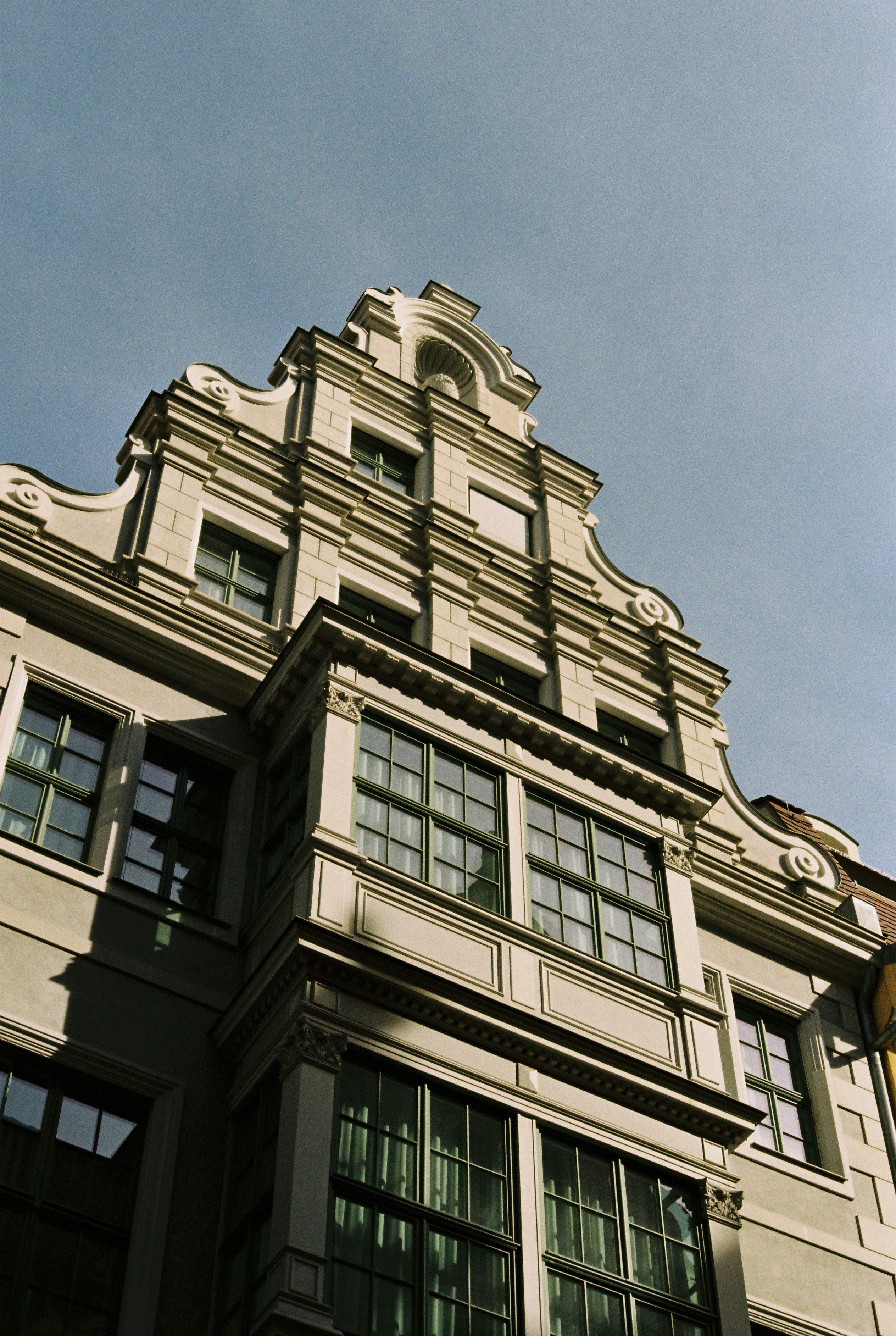 Fachada ornamentada de edificio histórico con ventana mirador.