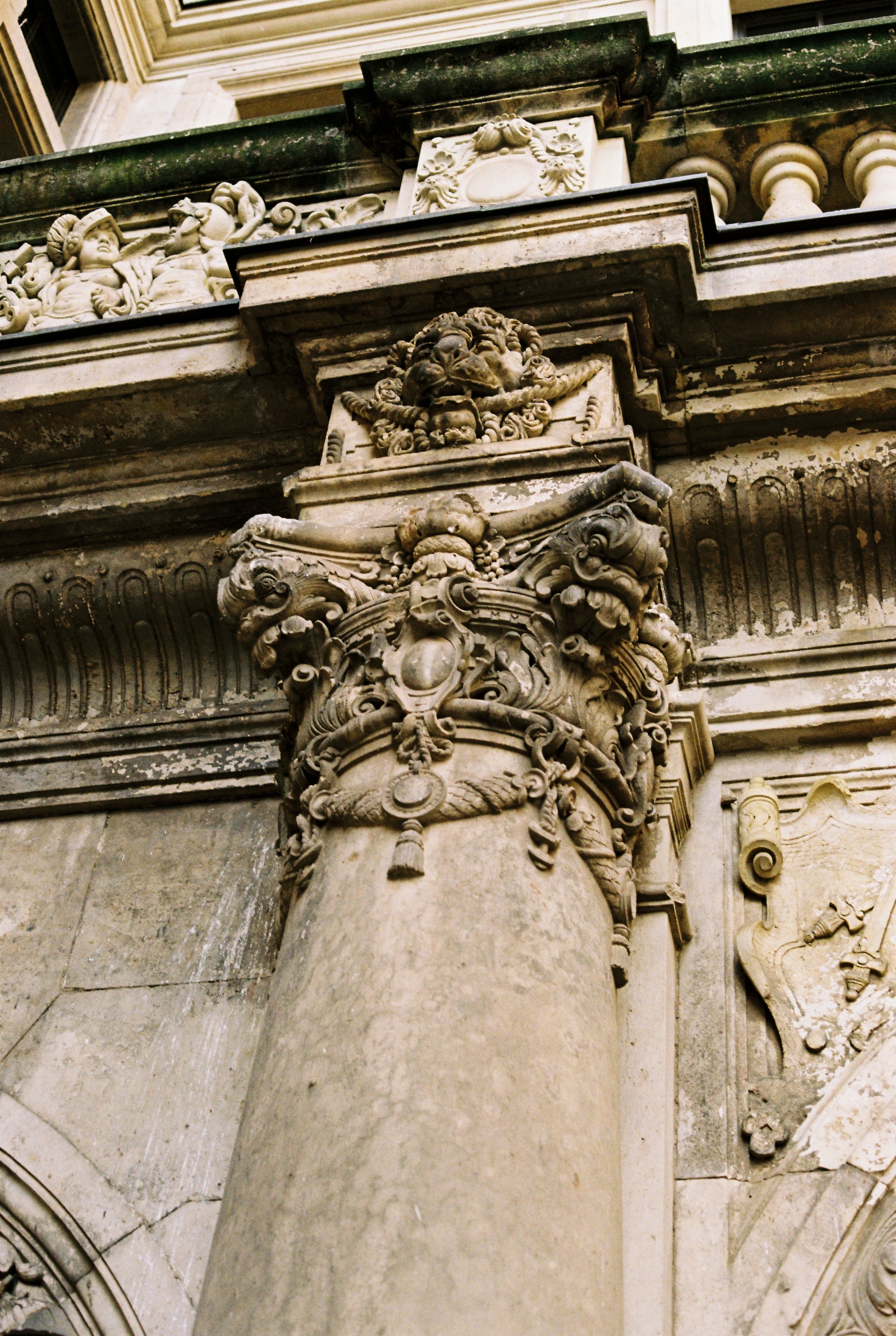 Columna de piedra ornamentada con tallas intrincadas y detalles arquitectónicos.