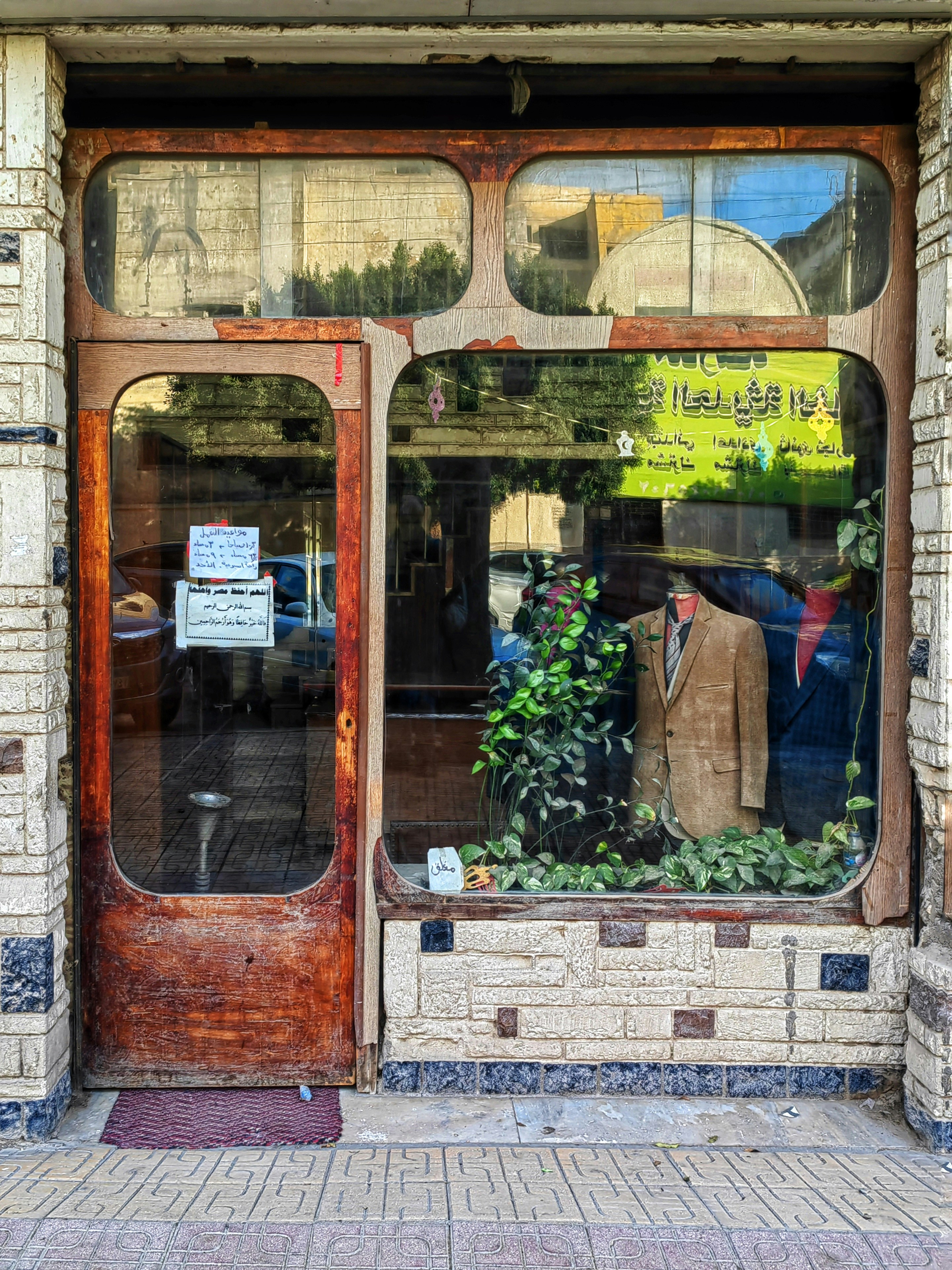 Mannequin in a suit displayed in a shop window.