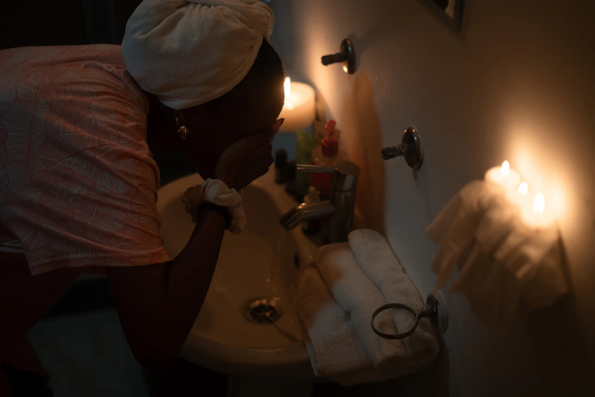 Woman washing her face in the evening by soft light