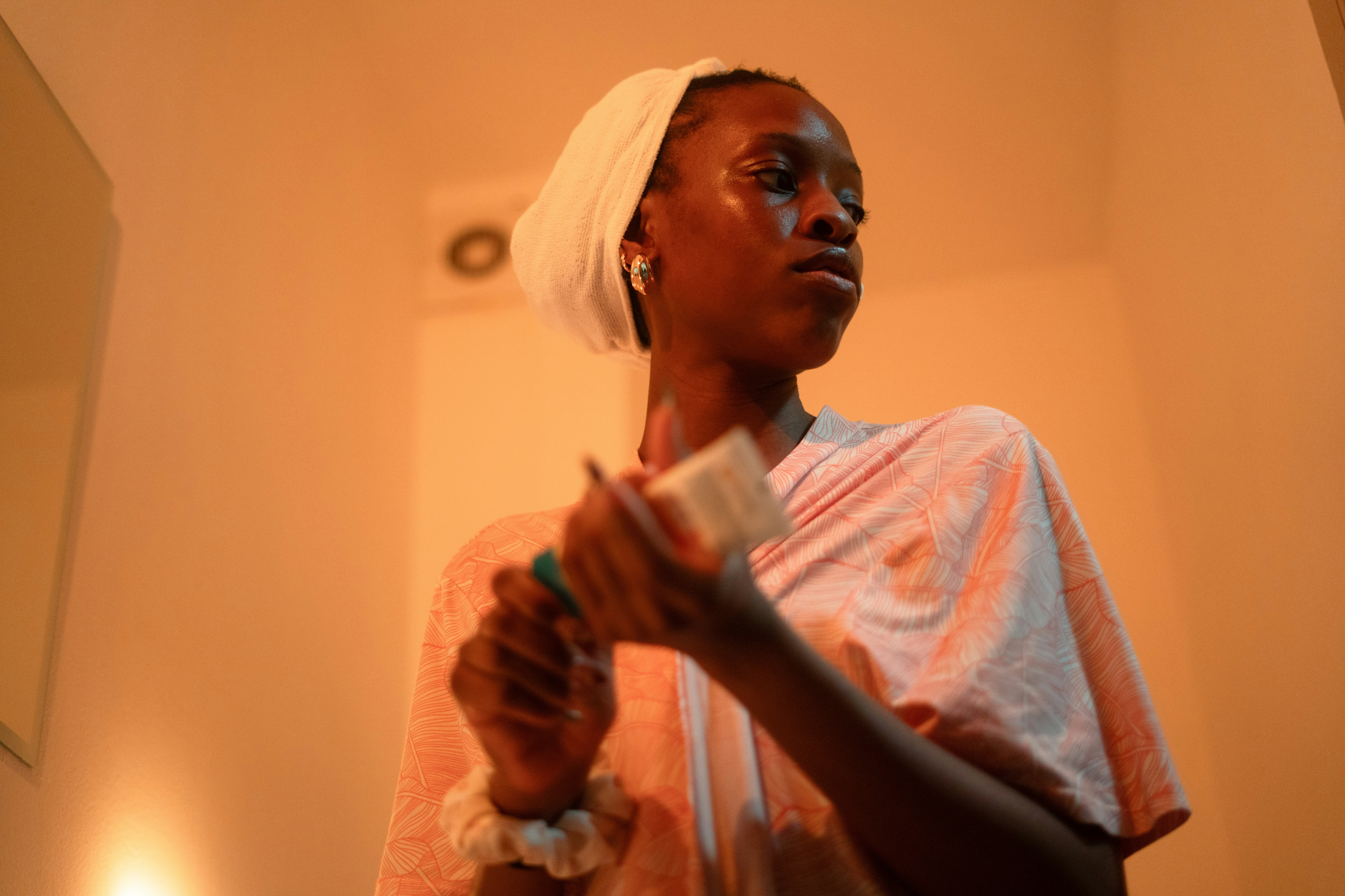 Young woman applies cream to her face