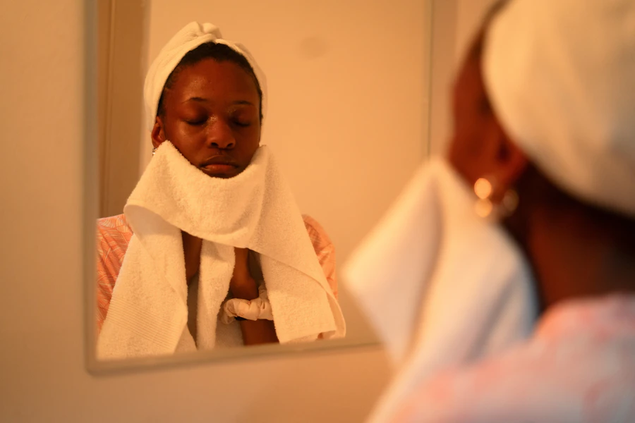 Woman with towel on head washing face