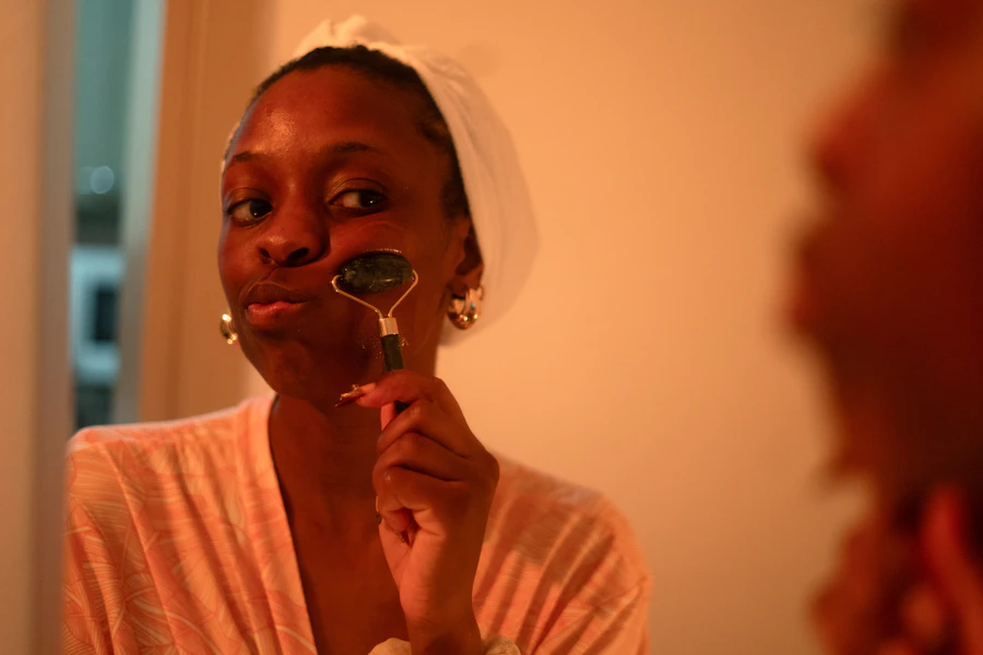 A woman uses a jade roller on her face