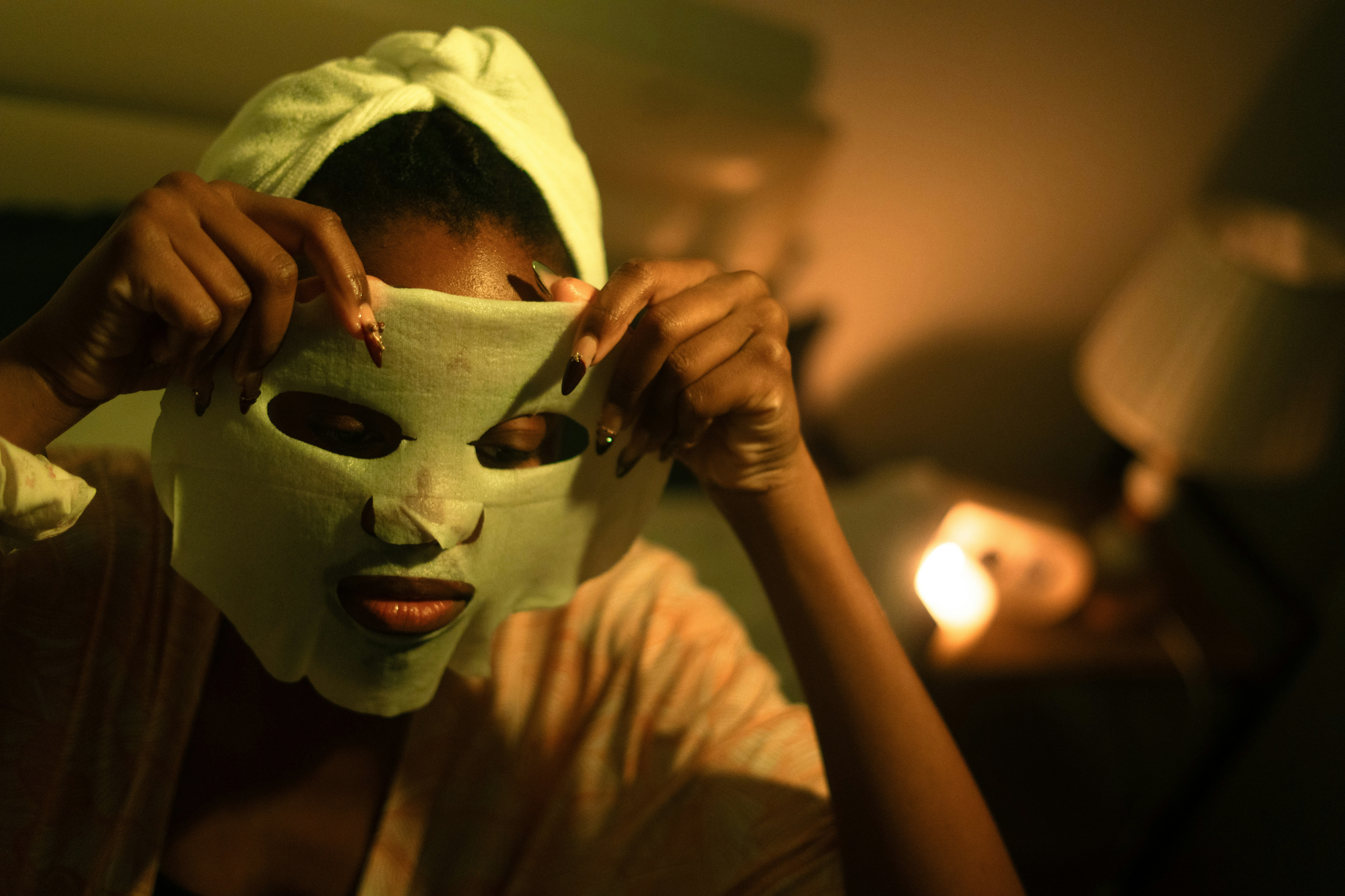 Woman applying a sheet mask to her face