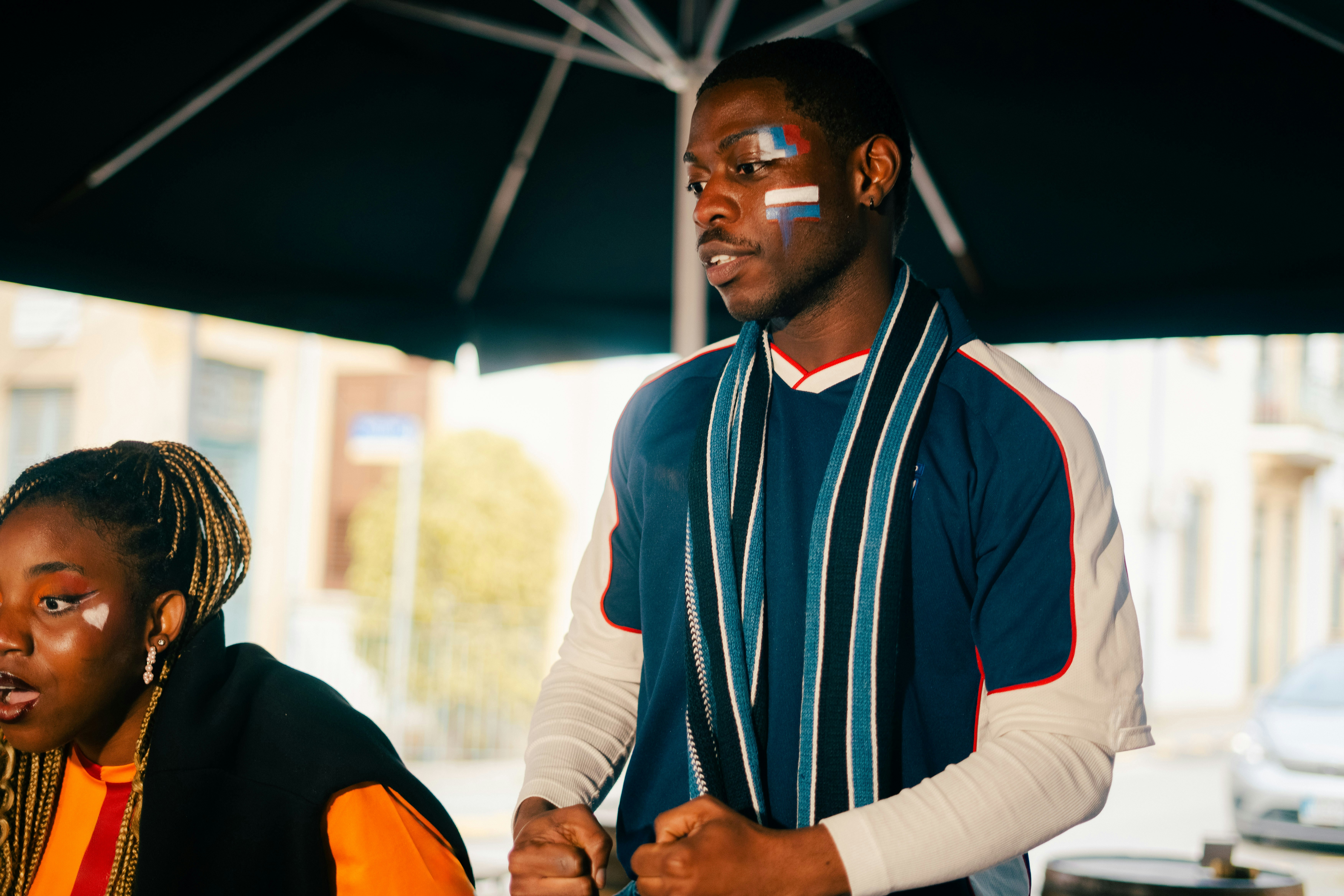 Un homme maquillé regardant un événement sportif.