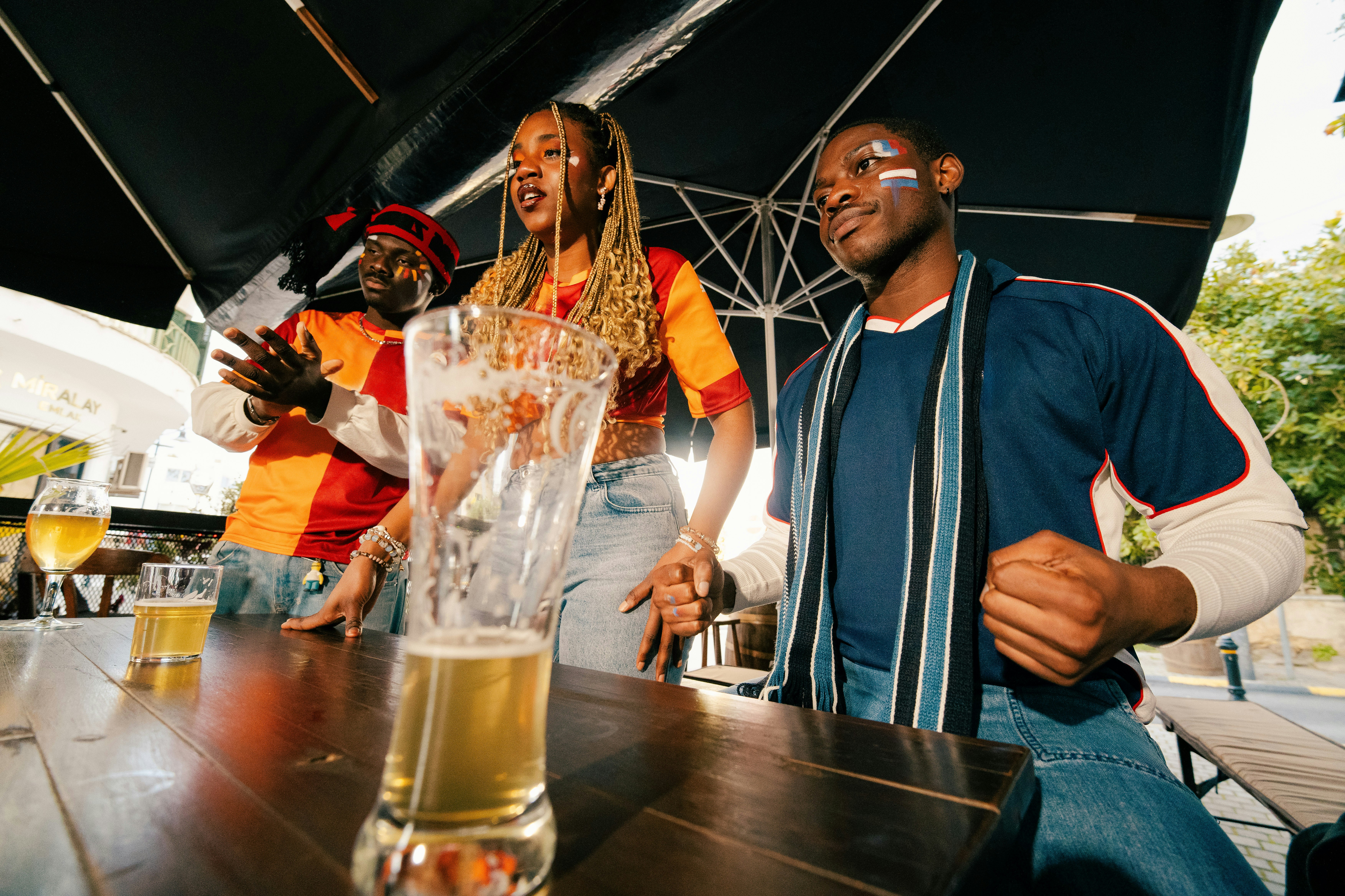 Aficionados viendo un partido intenso en un bar deportivo con pantallas grandes