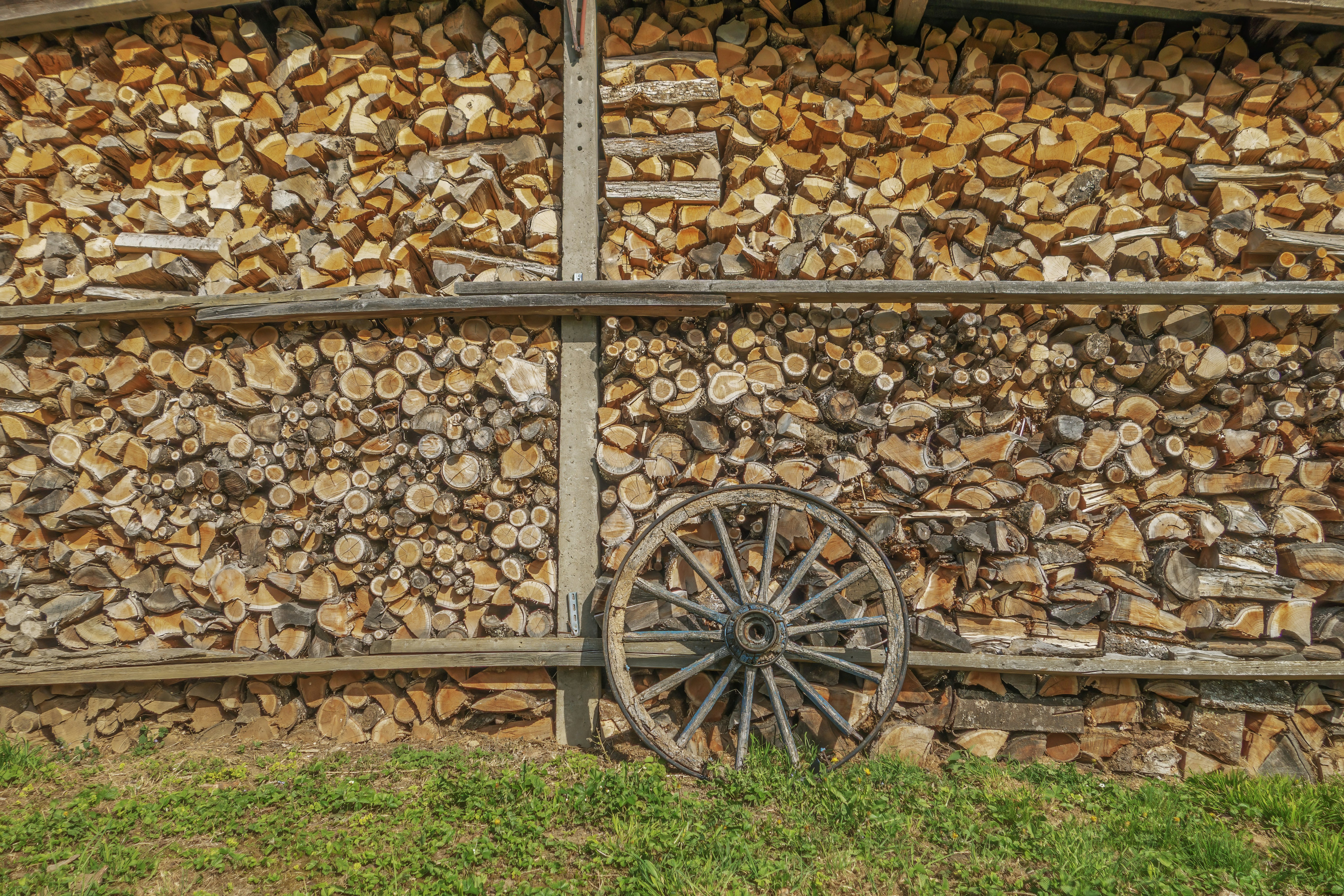 Lenha empilhada com uma roda de madeira antiga