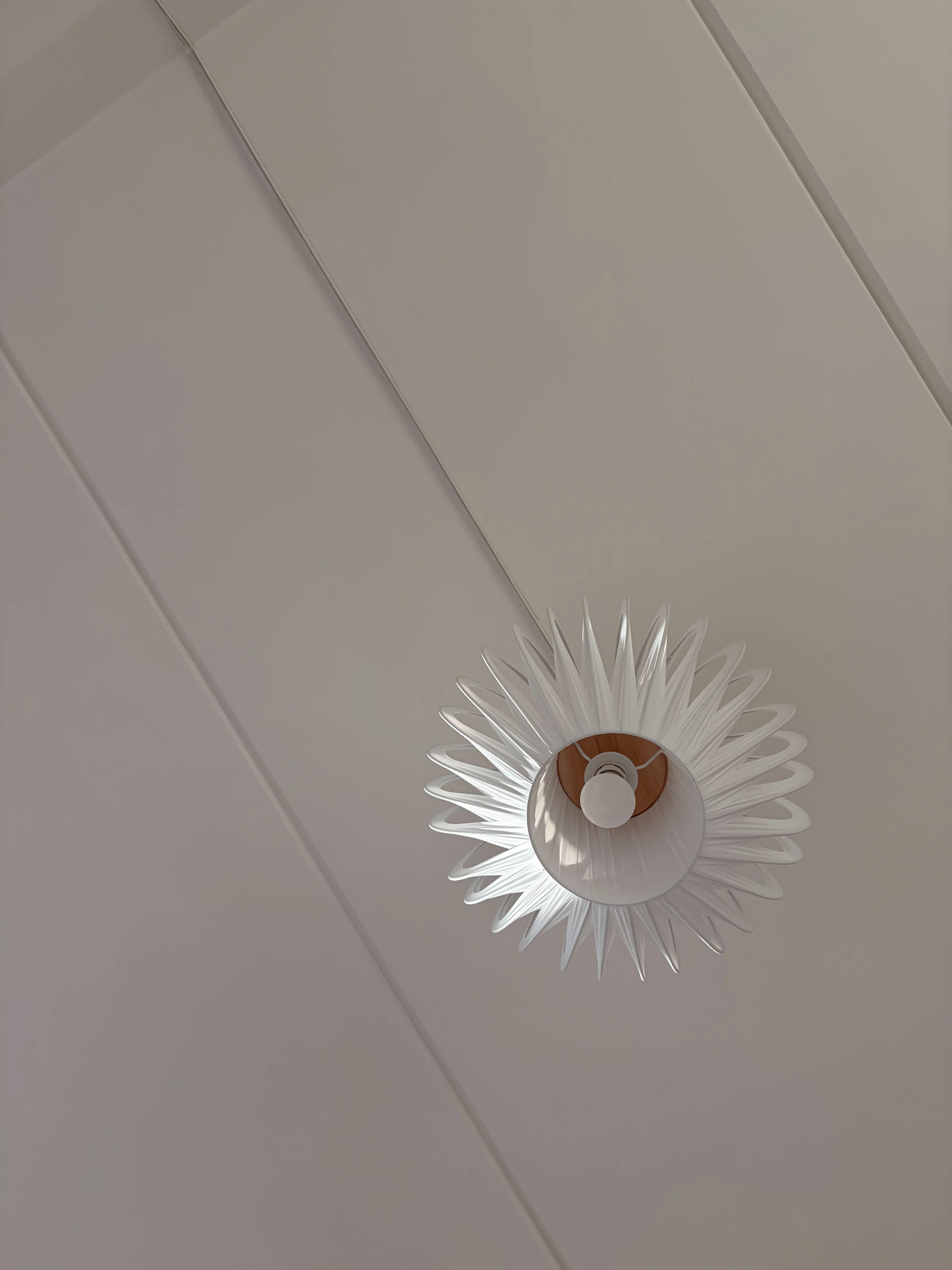 Modern white pendant light fixture hanging from ceiling