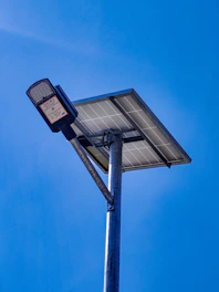 A solar-powered street lamp against a clear blue sky.