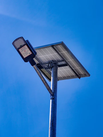 A solar-powered street lamp against a clear blue sky.