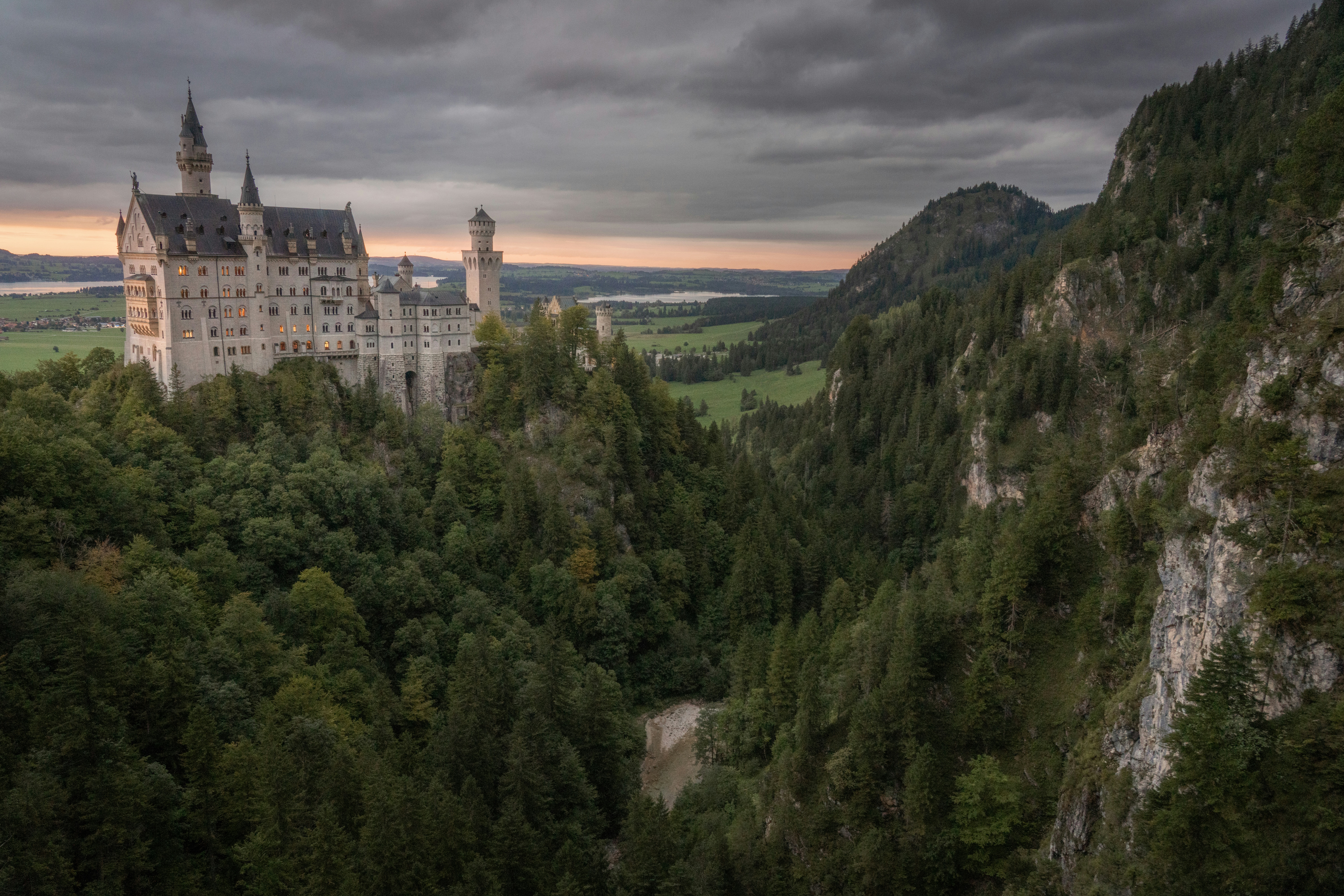 Majestic castle perched on a forested mountain cliff.