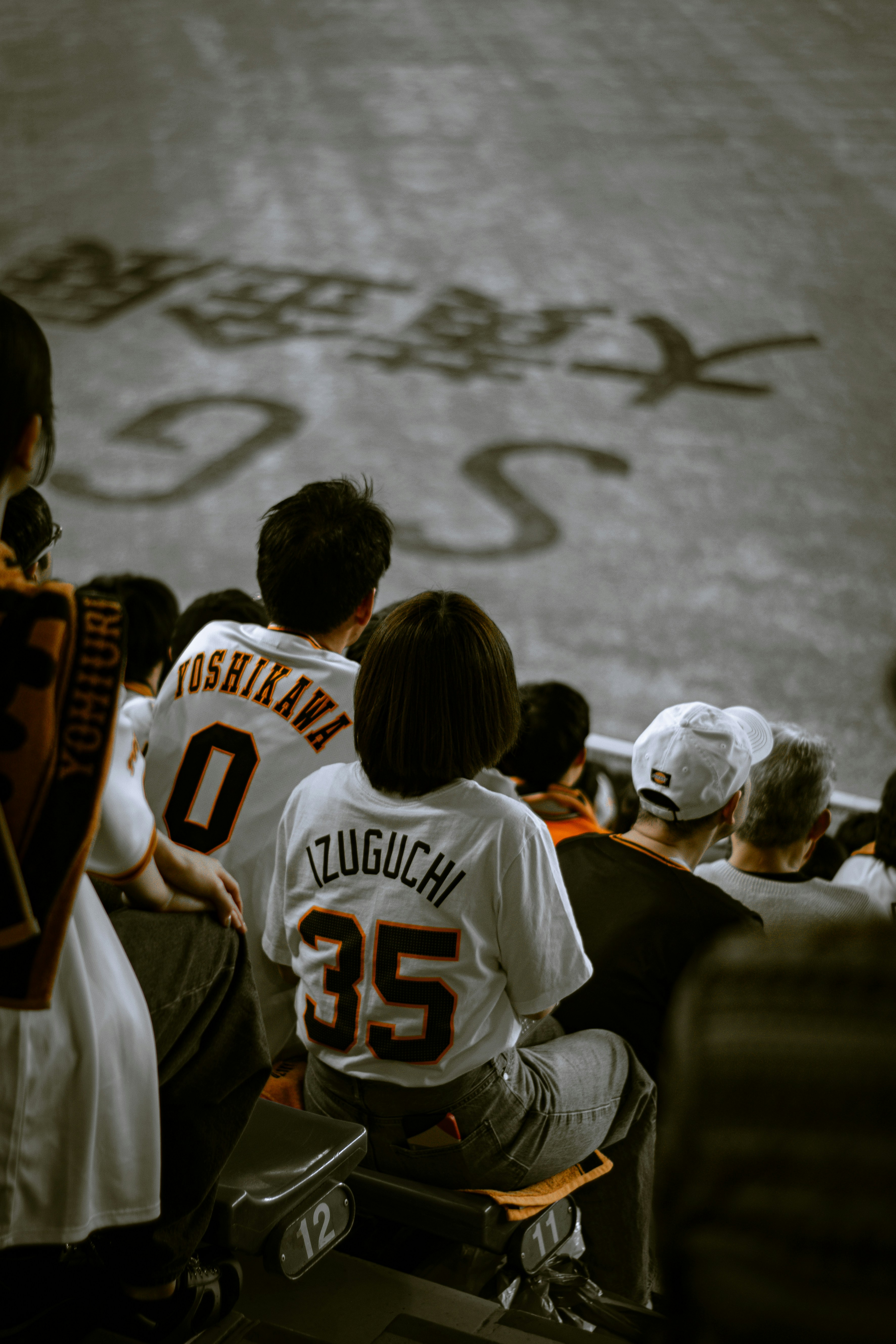 Spectators in baseball stadium seats watch the game.